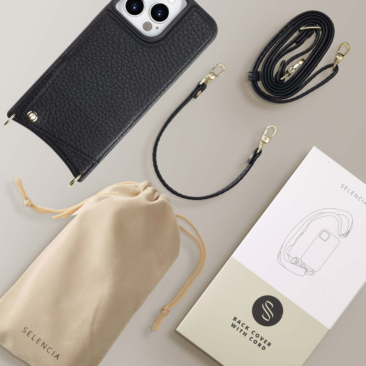 Een zwarte telefoonhoes met een riem, een draagtas en een productdoos met een telefoonillustratie.