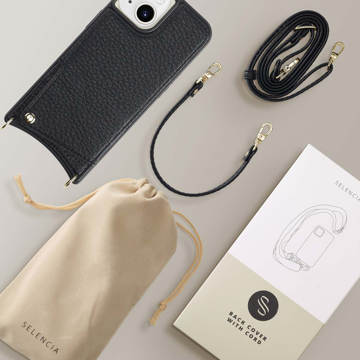 Een zwarte telefoonhoes met een zwarte riem, een zakje en een doos met een telefoontekening.