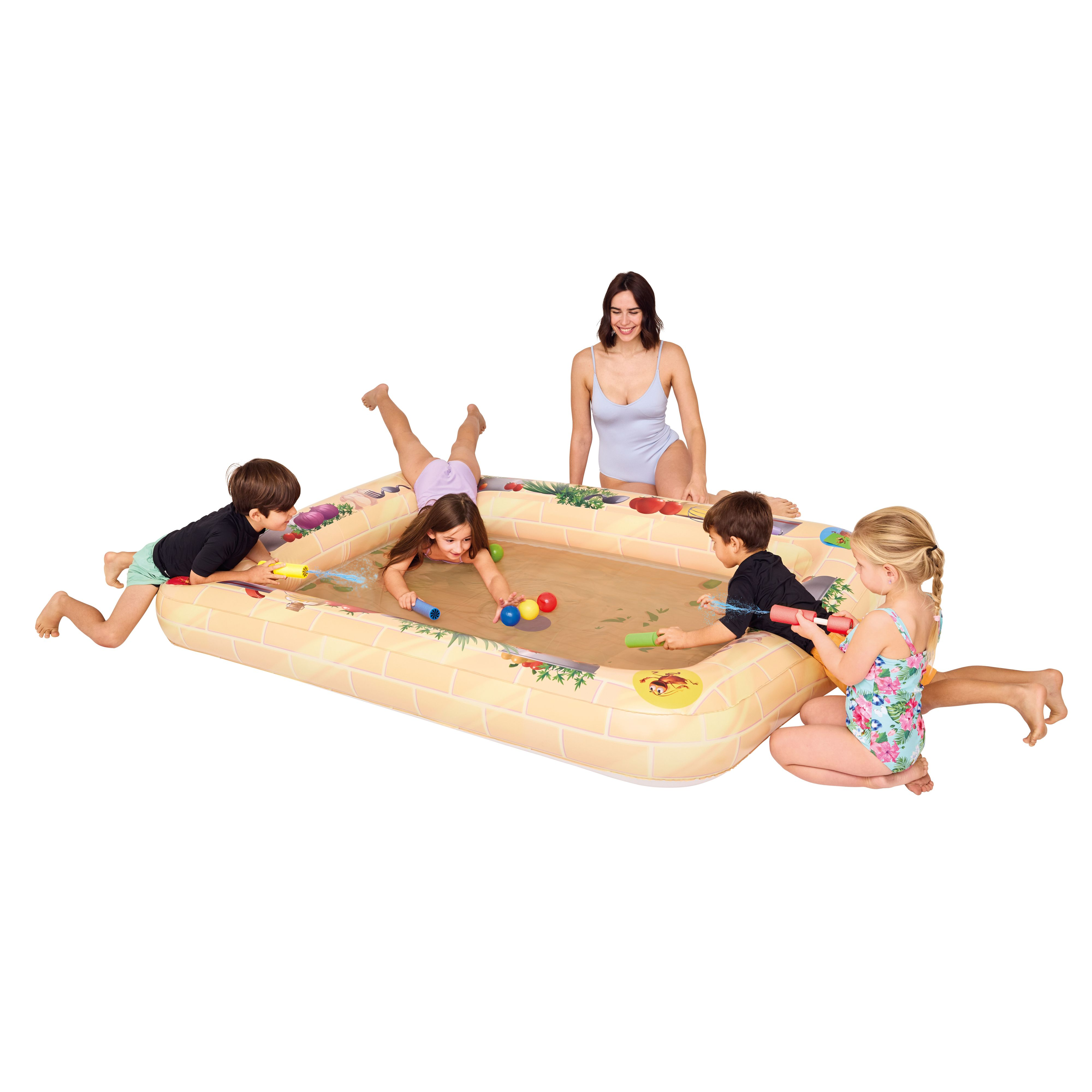 Kinder spielen in einem sandfarbenen aufblasbaren Pool. Eine Frau schaut zu. Wasserpistolen und Spielzeug sind sichtbar.