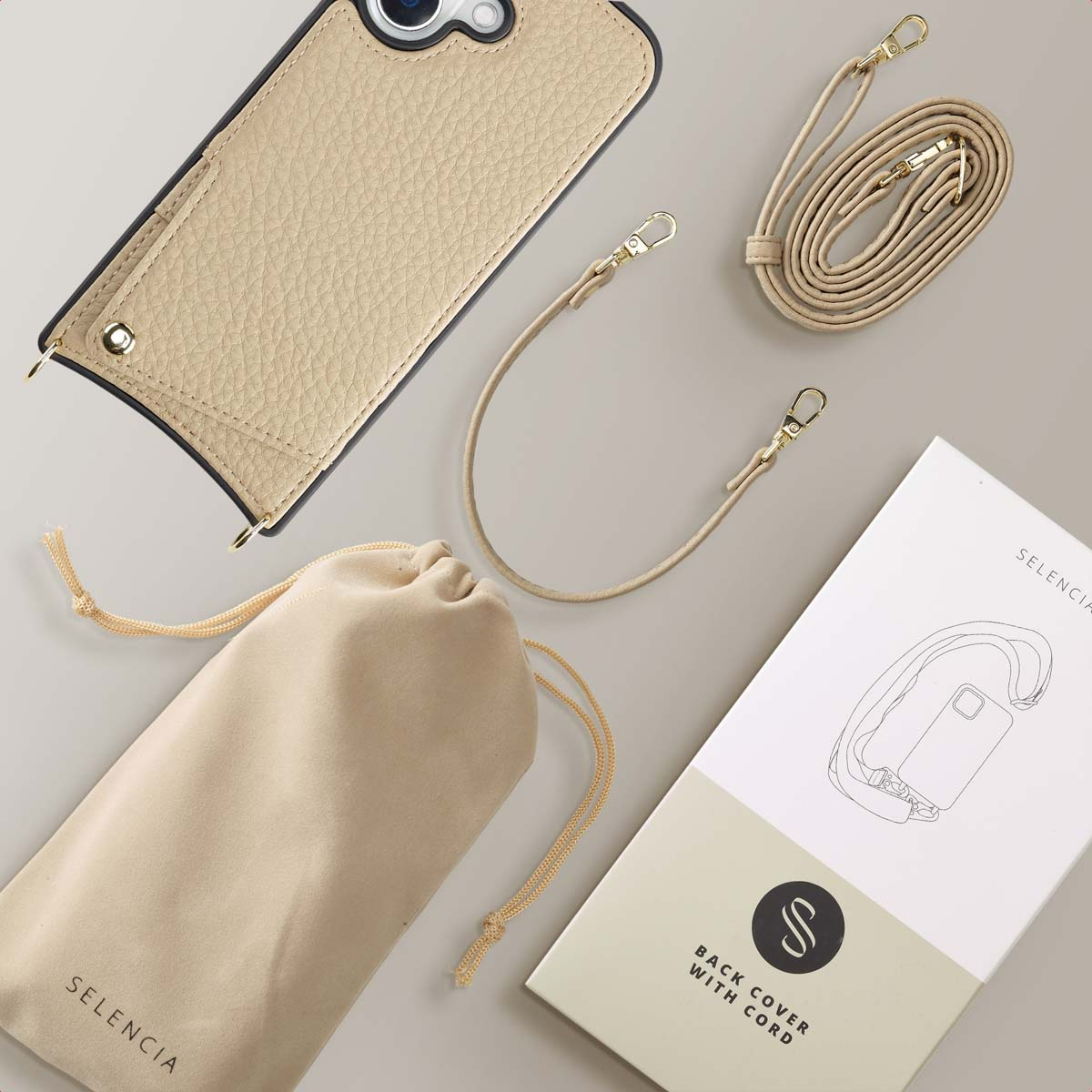Telefoonhoesje, koord, etui en doos op een neutraal gekleurd oppervlak.