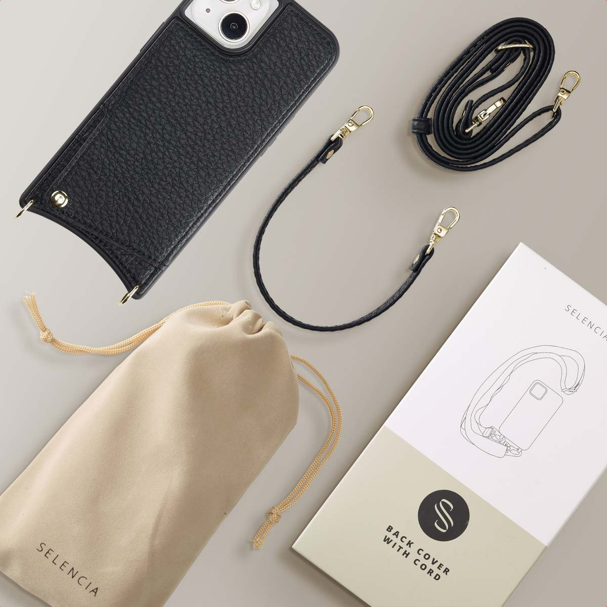 Coque de téléphone noire avec sangle, sac et cordon. Tous les articles sur une surface grise avec boîte blanche Selencia.