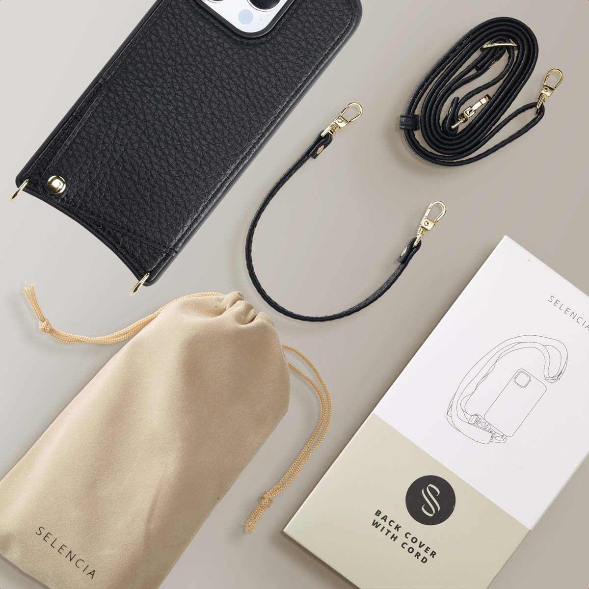 Een telefoonhoesje, een riem, een zakje en een doos met een koord en een telefoonhoesje.