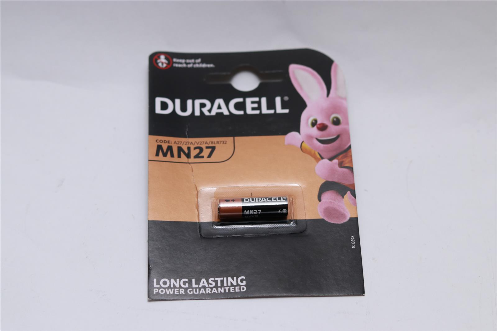 Confezione batterie Duracell MN27 con una mascotte a forma di coniglietto, su sfondo bianco. Testo: Potenza a lunga durata garantita.