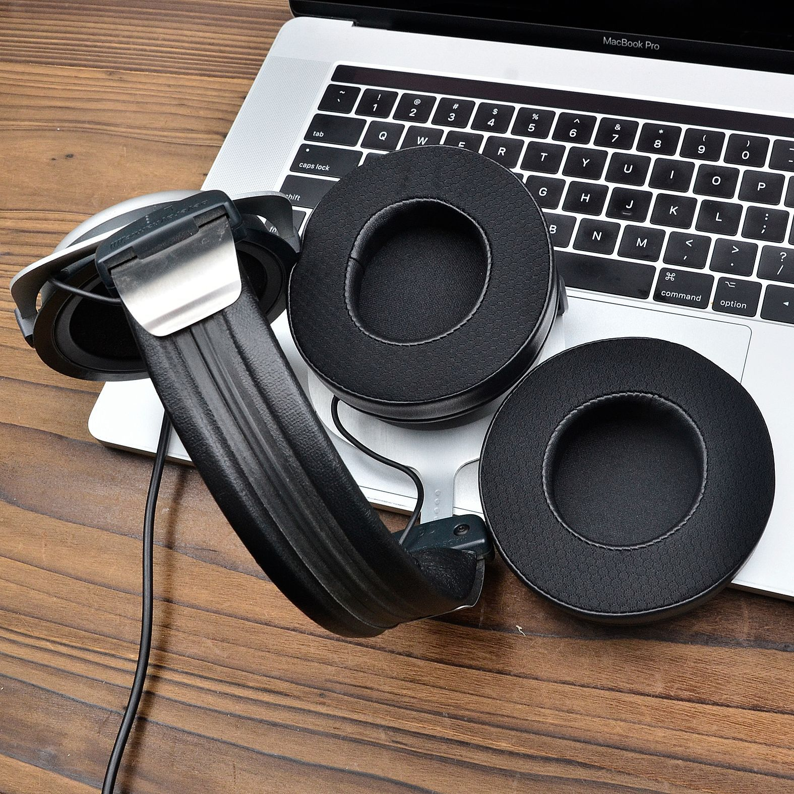 Słuchawki na laptopie, zbliżenie. Czarne nauszniki i srebrna opaska.