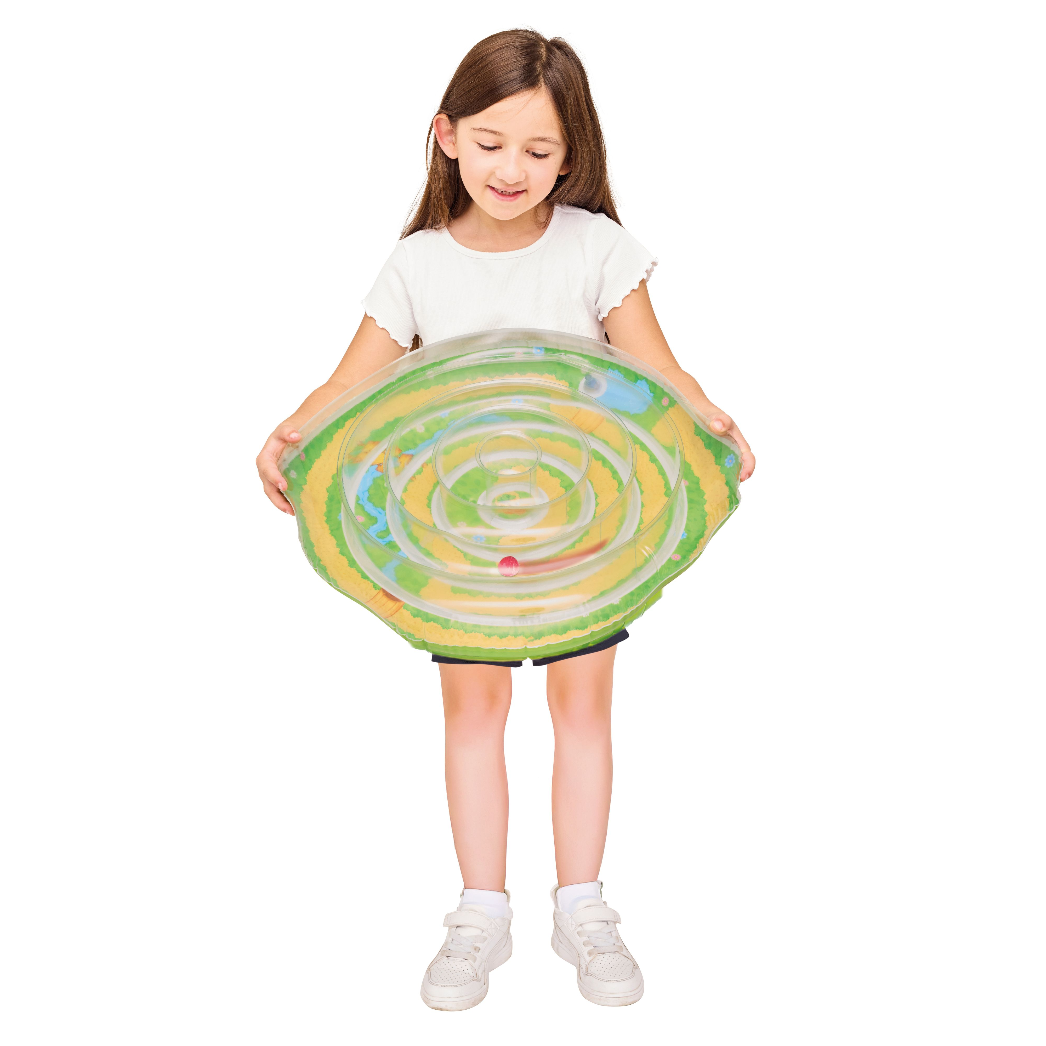 Junges Mädchen hält ein buntes Spielzeug mit Labyrinth-Design. Das Spielzeug ist transparent und rund.