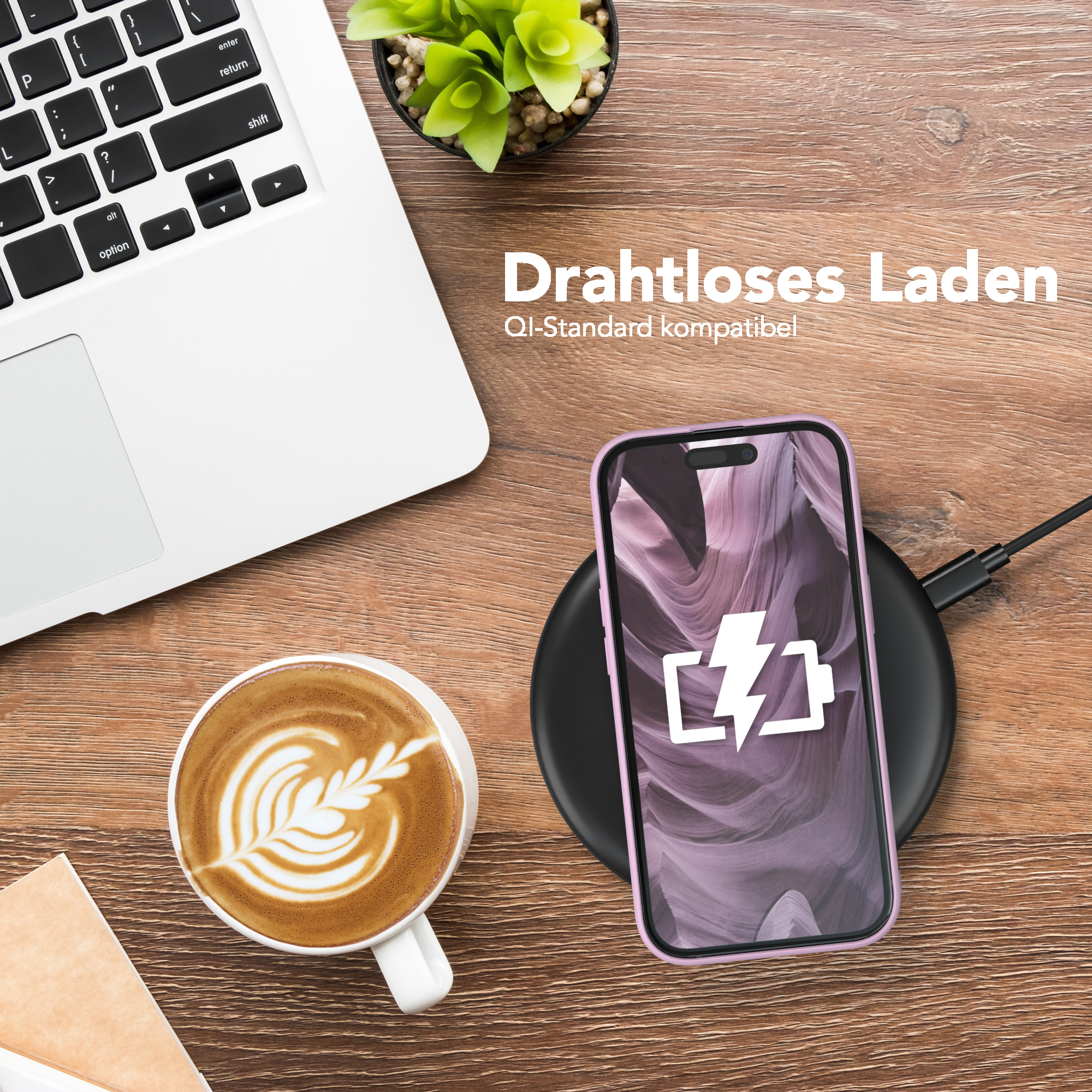 Ein Telefon, das auf einem kabellosen Pad neben einer Kaffeetasse und einem Laptop geladen wird.
