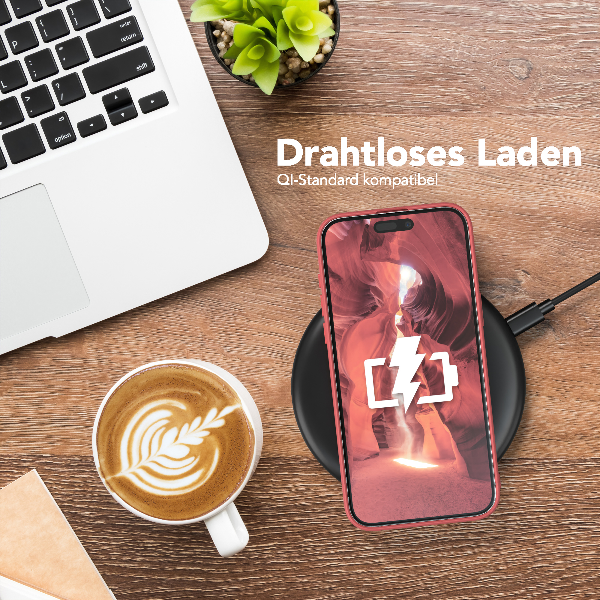 Telefon auf kabellosem Ladegerät, Kaffeetasse und Laptop auf einem Holztisch.