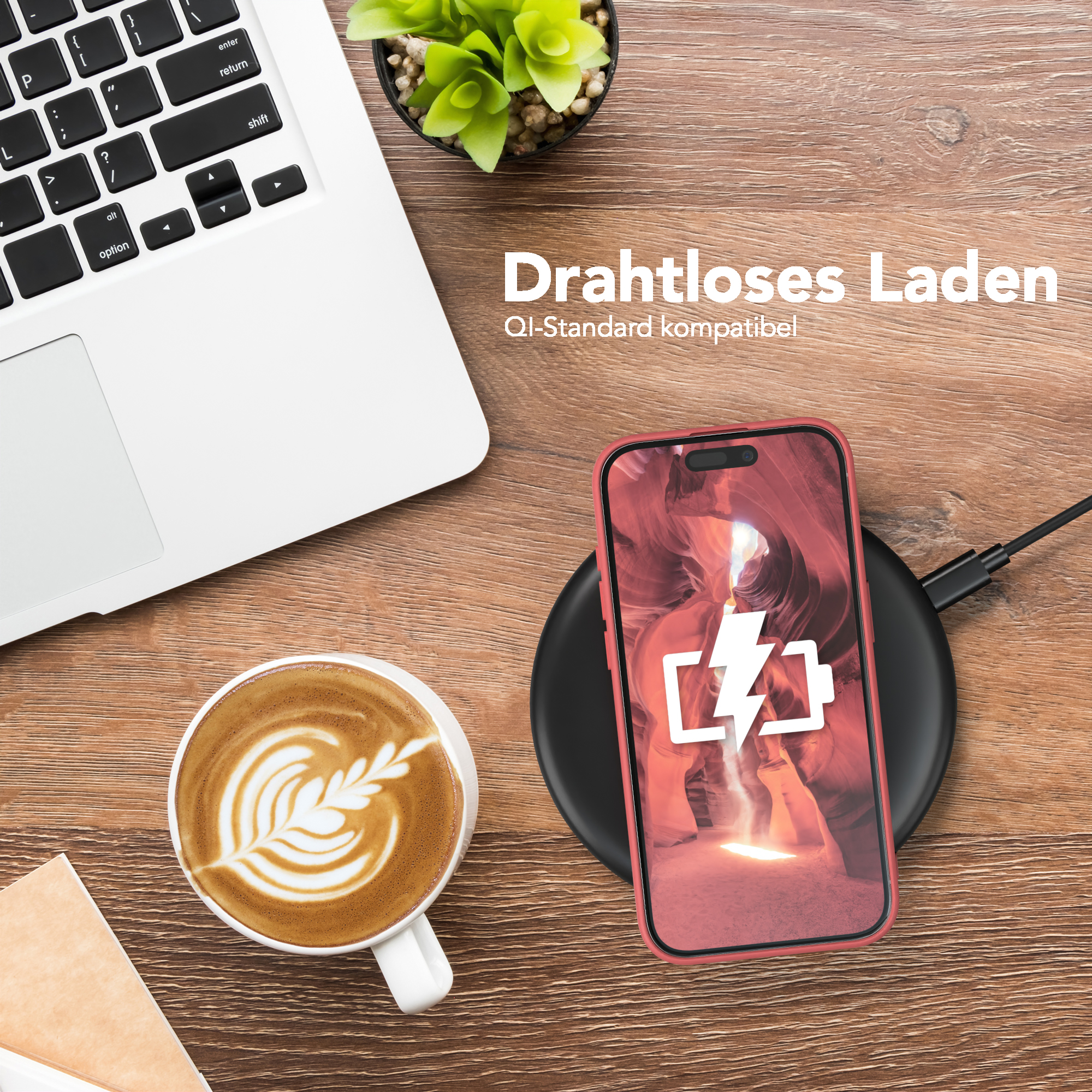 Ein Telefon, das auf einem kabellosen Ladegerät geladen wird. Eine Tasse Latte und ein Laptop sind in der Nähe.