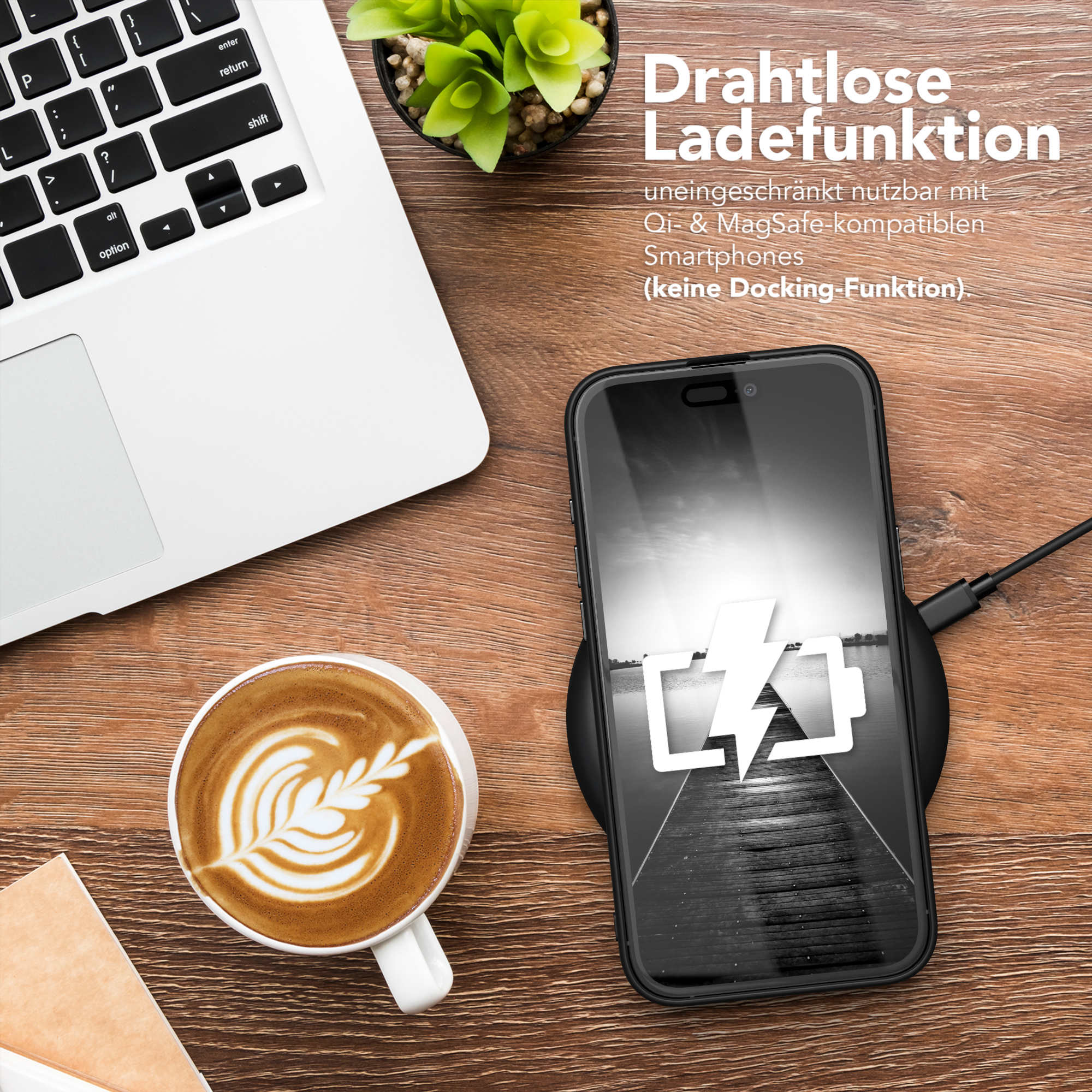 Ein Telefon, das drahtlos auf einem Pad geladen wird, neben einer Kaffeetasse und einem Laptop. Holzschreibtischhintergrund.