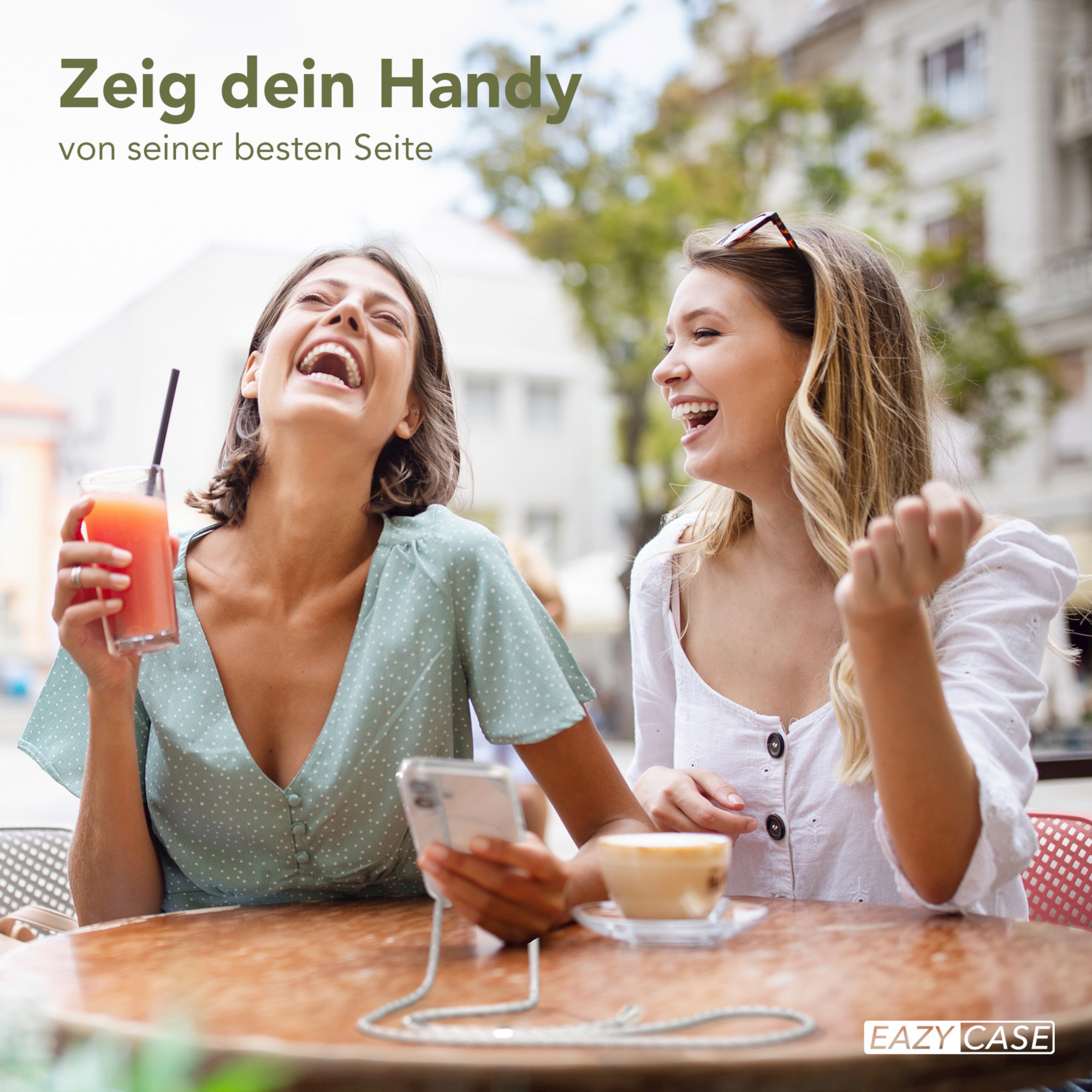Zwei lachende Frauen, eine hält ein Getränk und ein Telefon mit Kordel.