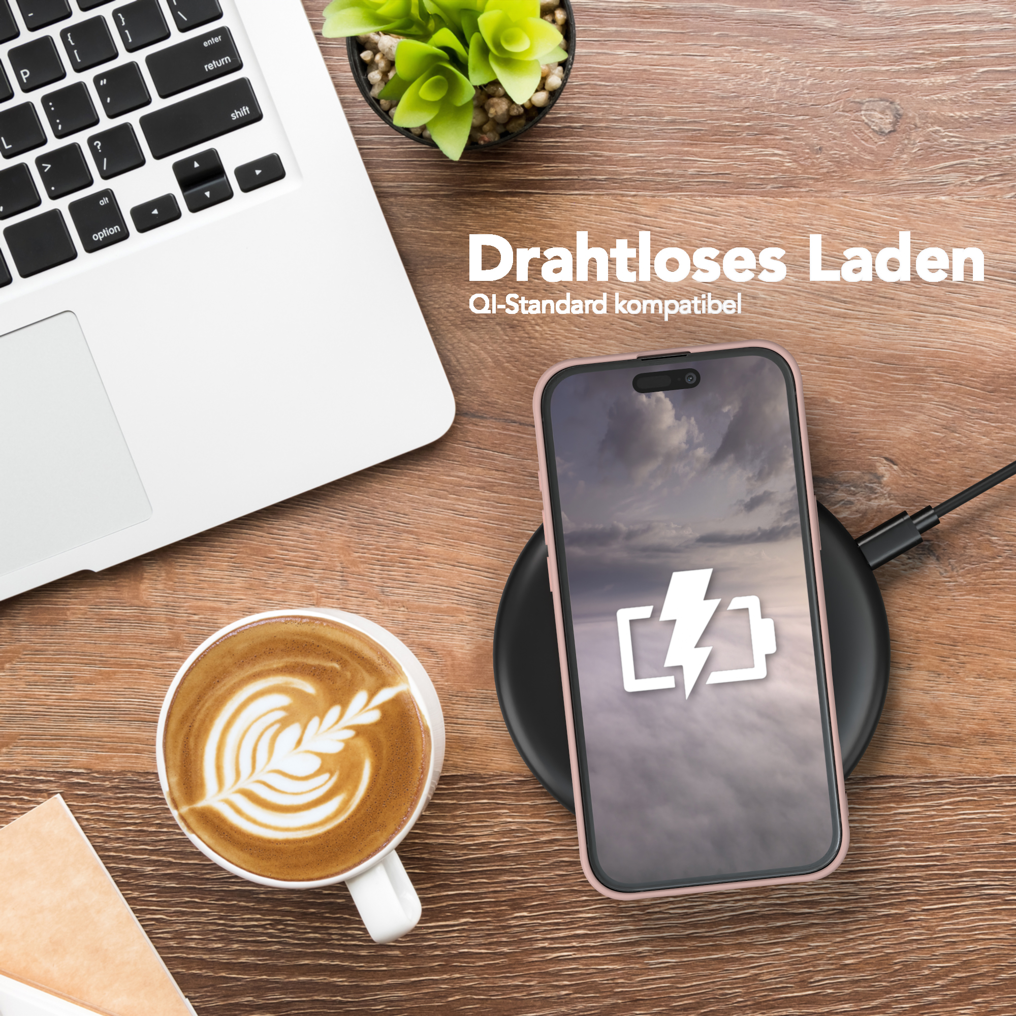 Telefon wird kabellos auf einem Pad aufgeladen, neben einer Kaffeetasse und einem Laptop.