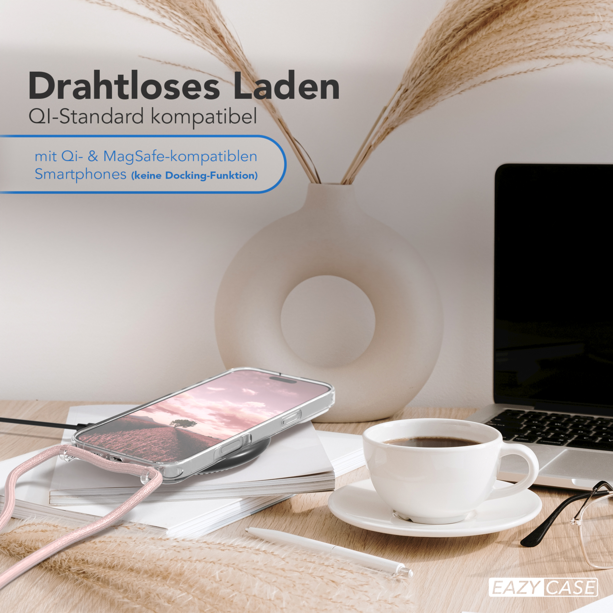 Ein Telefon auf einem kabellosen Ladegerät, eine Tasse Kaffee und eine Vase mit Pampasgras.