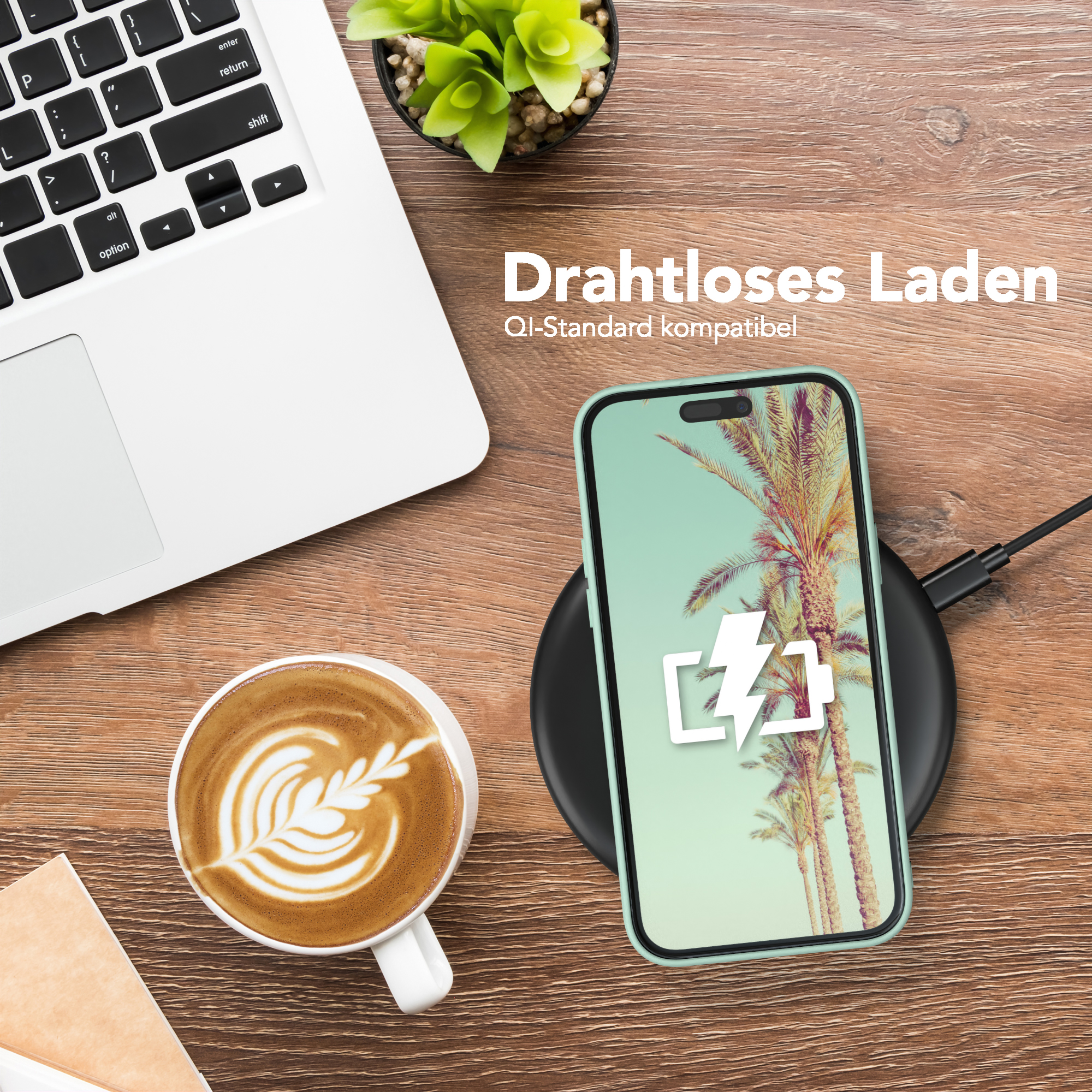 Telefon mit hellgrüner Hülle, lädt auf einem schwarzen Pad. Laptop und Kaffeetasse ebenfalls auf dem Schreibtisch.