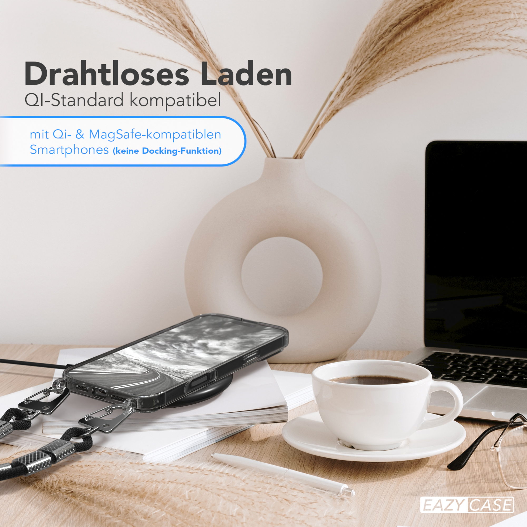 Ein Telefon auf einem kabellosen Ladegerät mit Lanyard. Es gibt eine Vase mit Pflanzen, eine Kaffeetasse und Gläser.