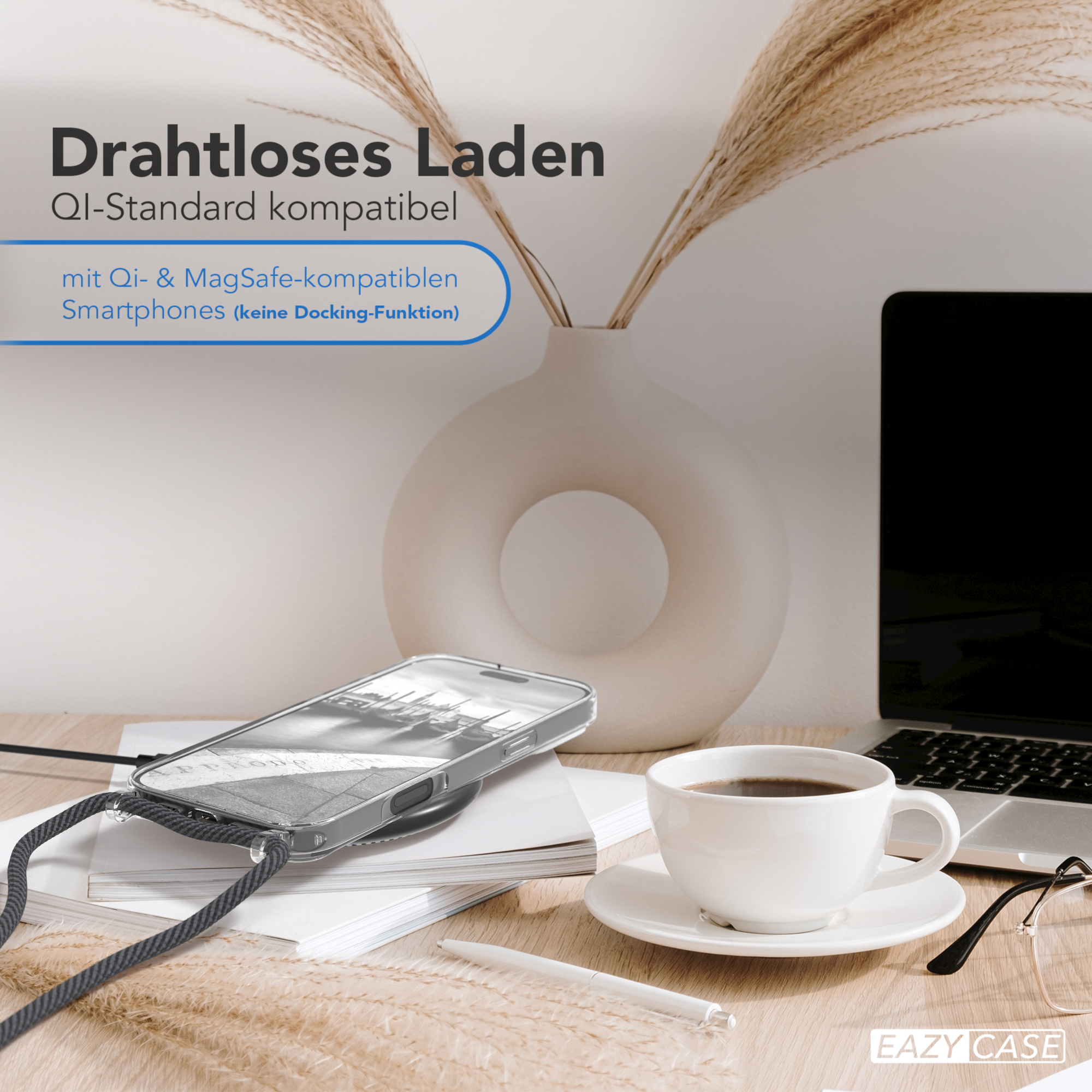 Ein Telefon in einer transparenten Hülle, eine Tasse Kaffee, ein Laptop und eine Pflanze stehen auf einem Holztisch.