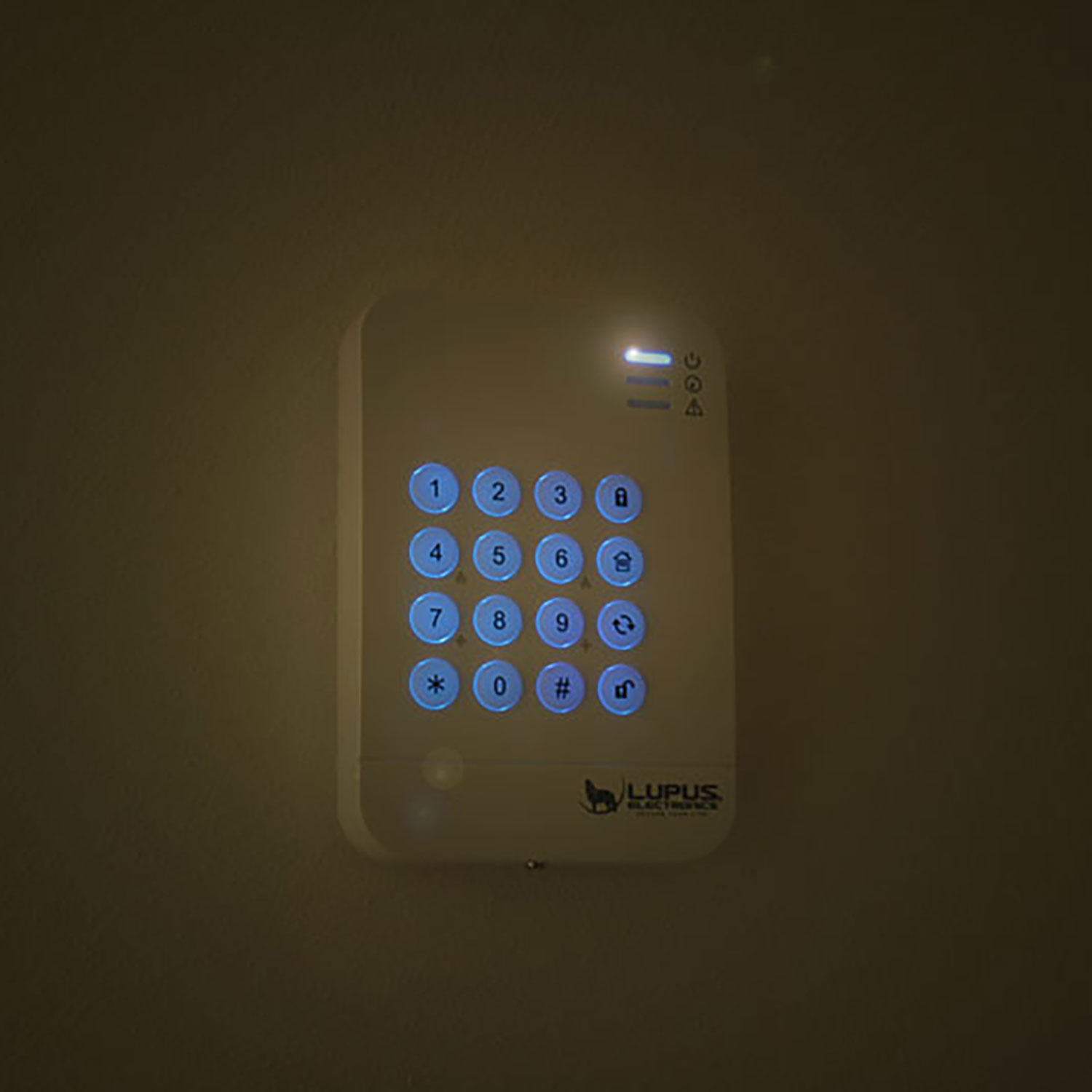 Sicherheits-Tastatur an der Wand mit blau beleuchteten Tasten. LUPUS ELECTRONICS Logo.