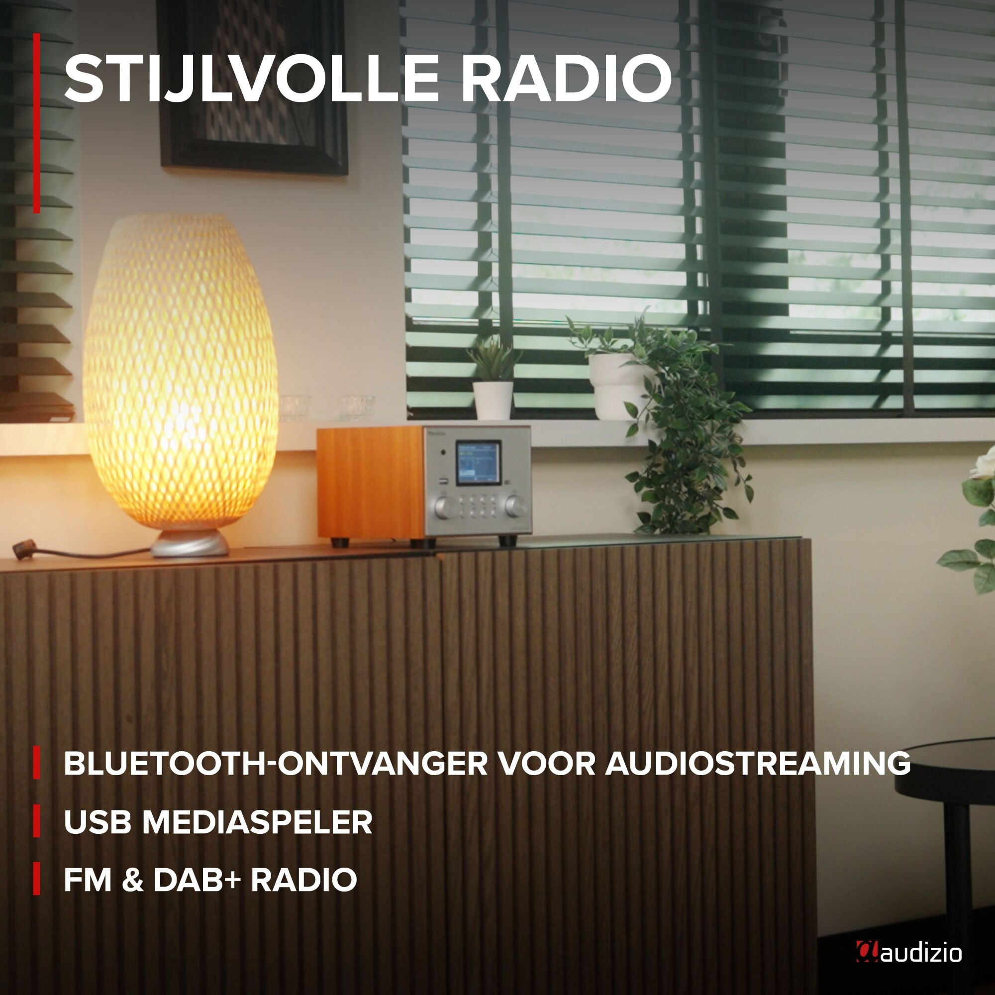 Ein Holzschrank mit Lampe und Radio obenauf und grünen Jalousien.