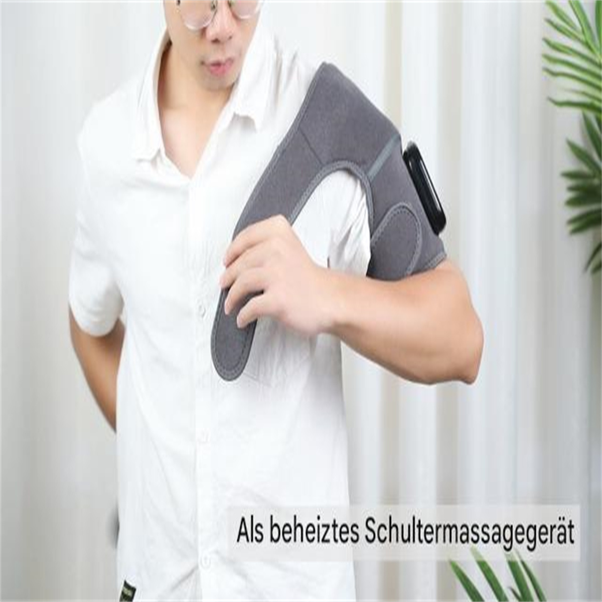 Mann trägt Schultermassagegerät. Weißes Hemd. Text unten: Beheiztes Schultermassagegerät.