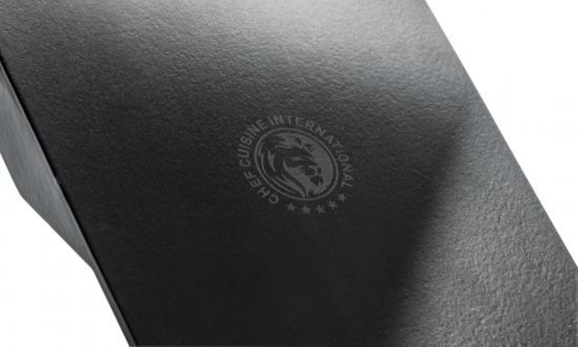 Nahaufnahme einer schwarzen Box mit einem Logo eines Löwen in einem Kreis, mit Text: CHEF CUISINE INTERNATIONAL.