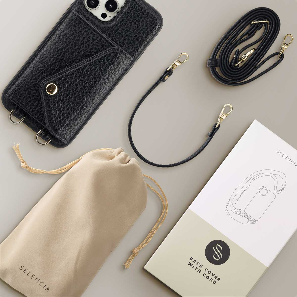 Zwarte leren telefoonhoes, zwart koord en een beige zakje met een doos met de afbeelding van de telefoon.