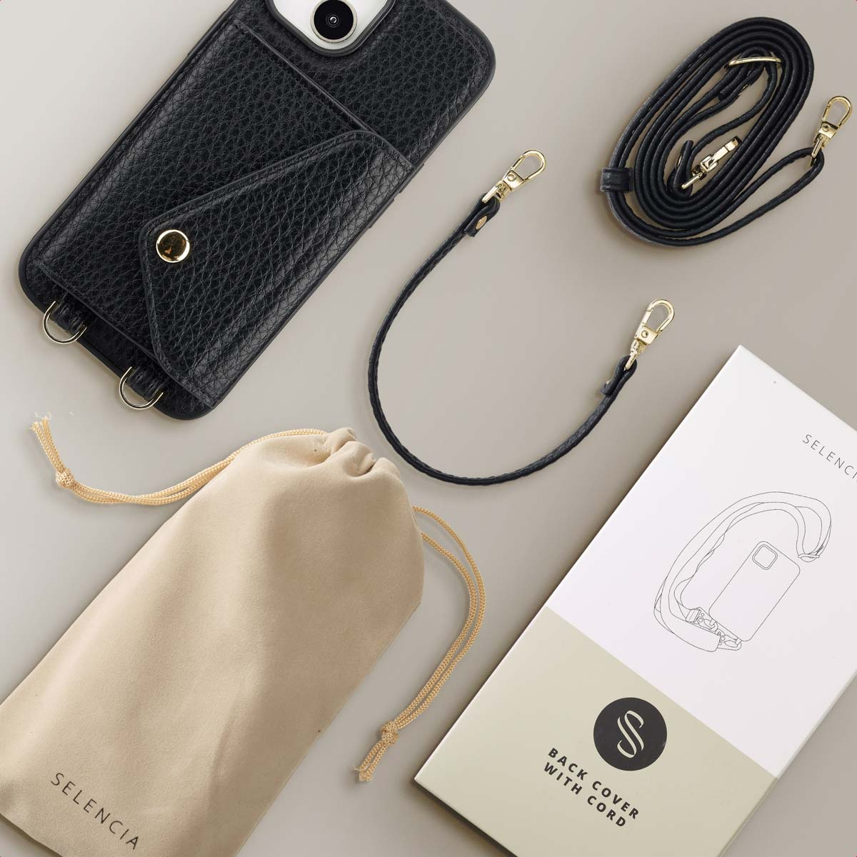 Een telefoonhoesje met een riem en een zakje, accessoires op een wit oppervlak.