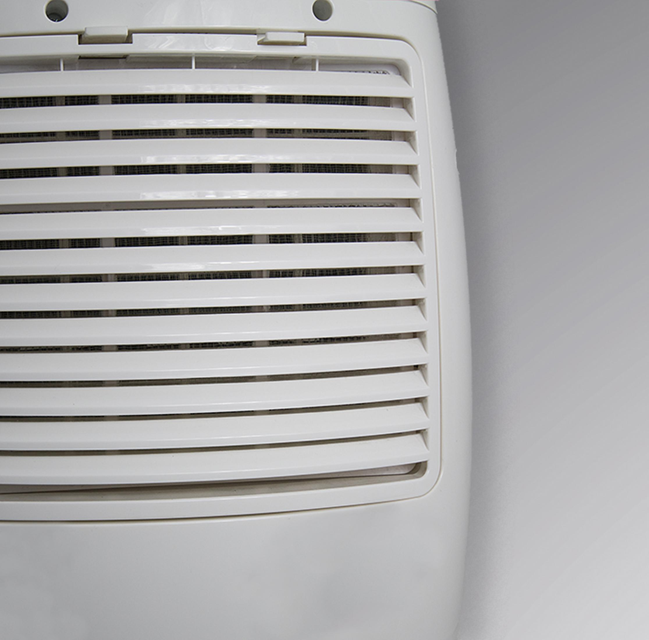 Grille d'aération blanche avec lamelles horizontales sur fond blanc, gros plan.