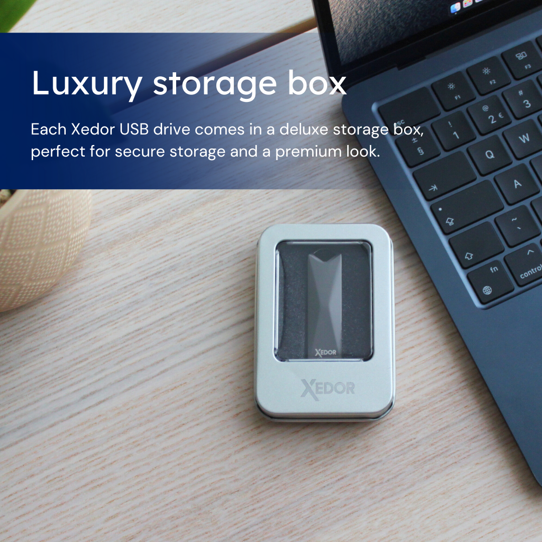 Een zilveren doos met een USB-stick erin. De doos staat op een houten tafel.