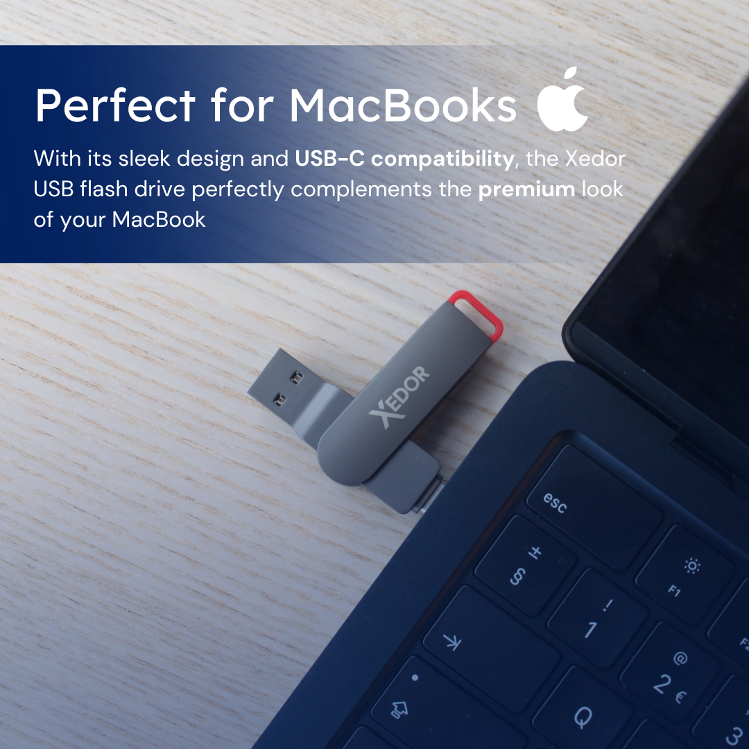 Een grijze USB-stick met een rood uiteinde, naast een laptoptoetsenbord. De achtergrond is een bureau.