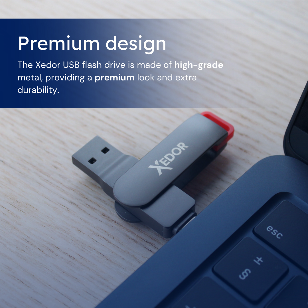 Zilveren USB-stick met een rode punt. Het ligt op een houten oppervlak in de buurt van een laptoptoetsenbord.