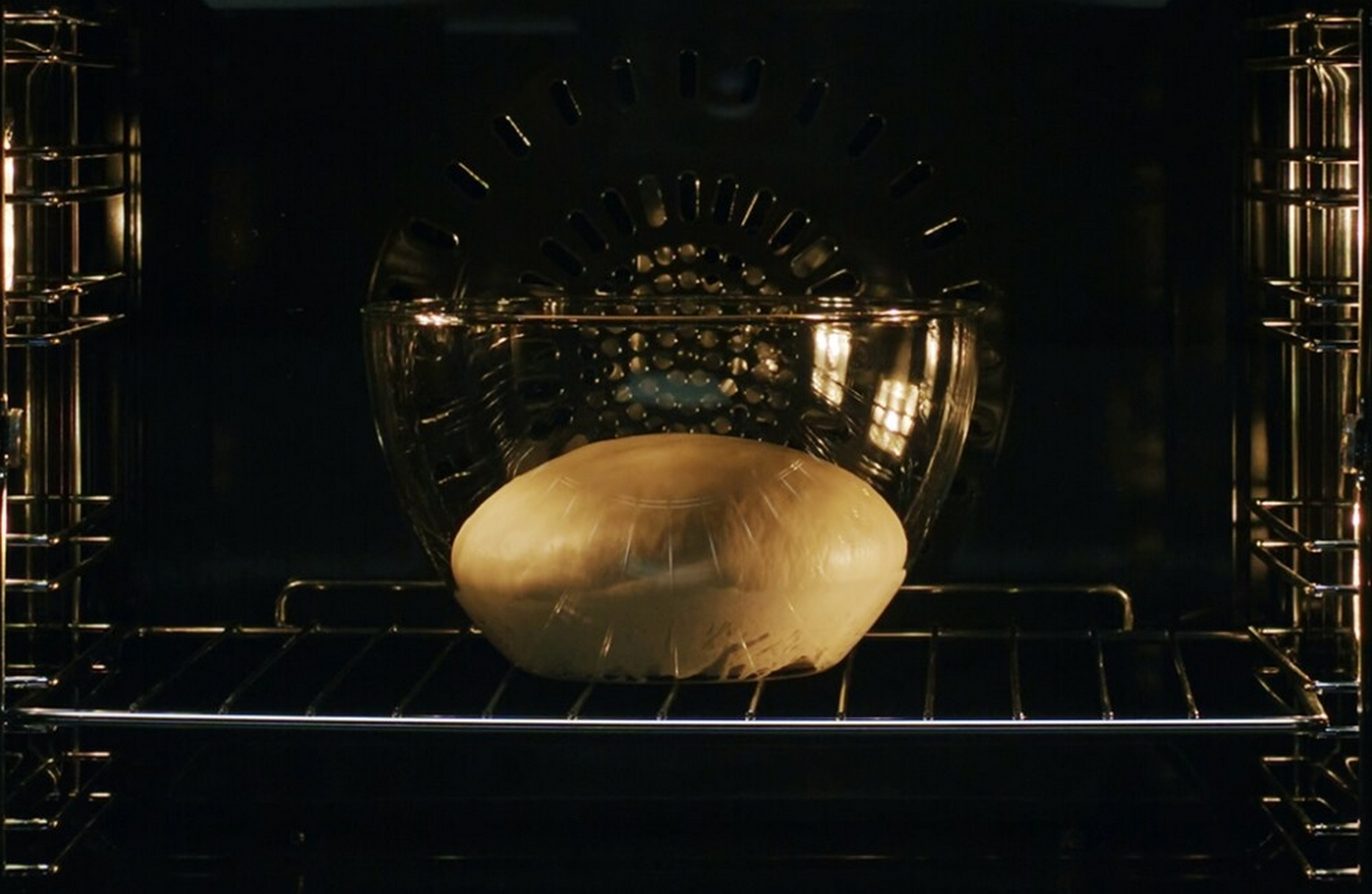 All'interno di un forno, una pagnotta in un contenitore di vetro sulla griglia.