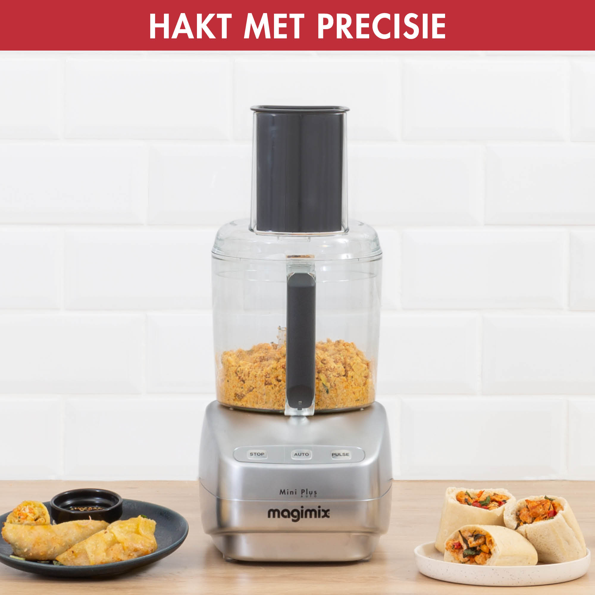 Keukenmachine met eten, in kommen en loempia's aan de zijkant.