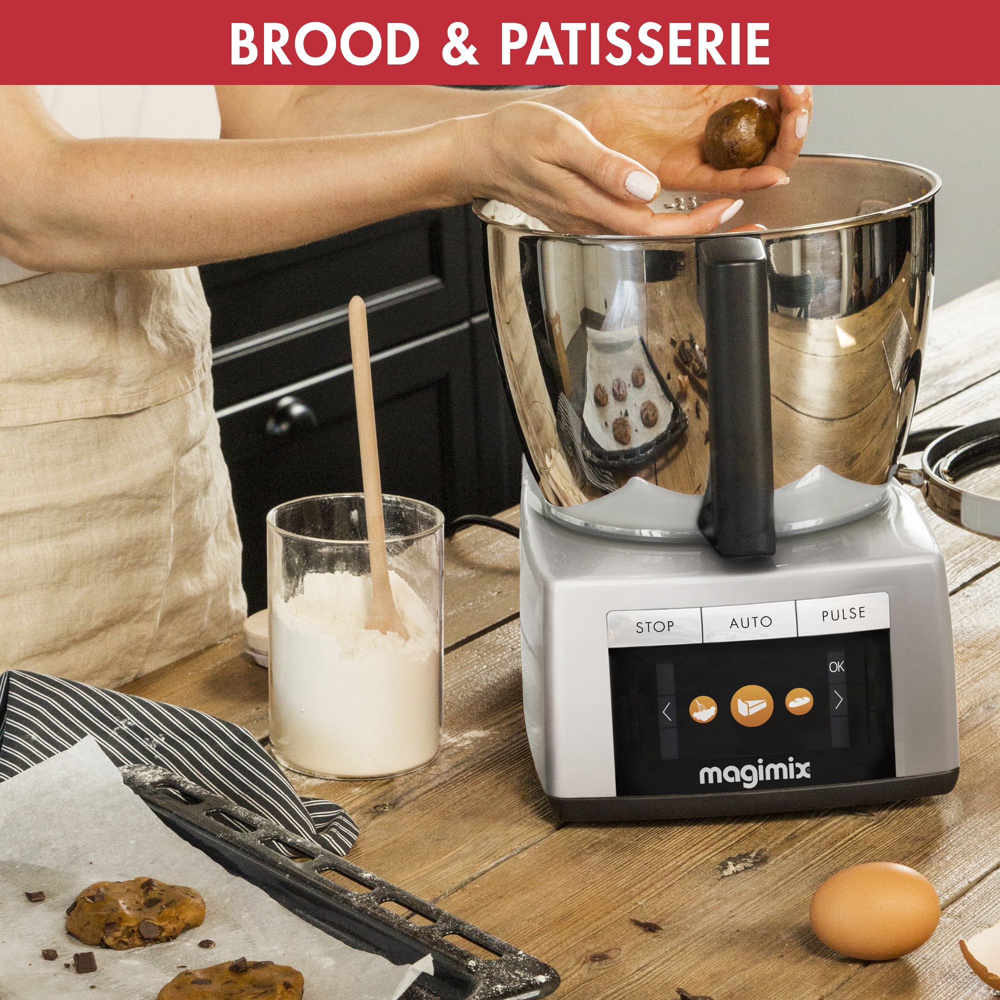 A person making cookies with a food processor. Ingredients are on a wooden counter.