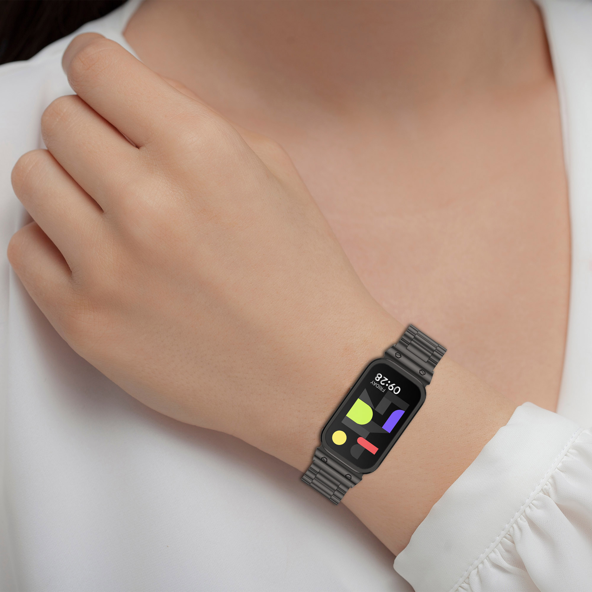 Person trägt Smartwatch. Smartwatch hat farbenfrohes Display. Graues Armband. Weißes Hemd.