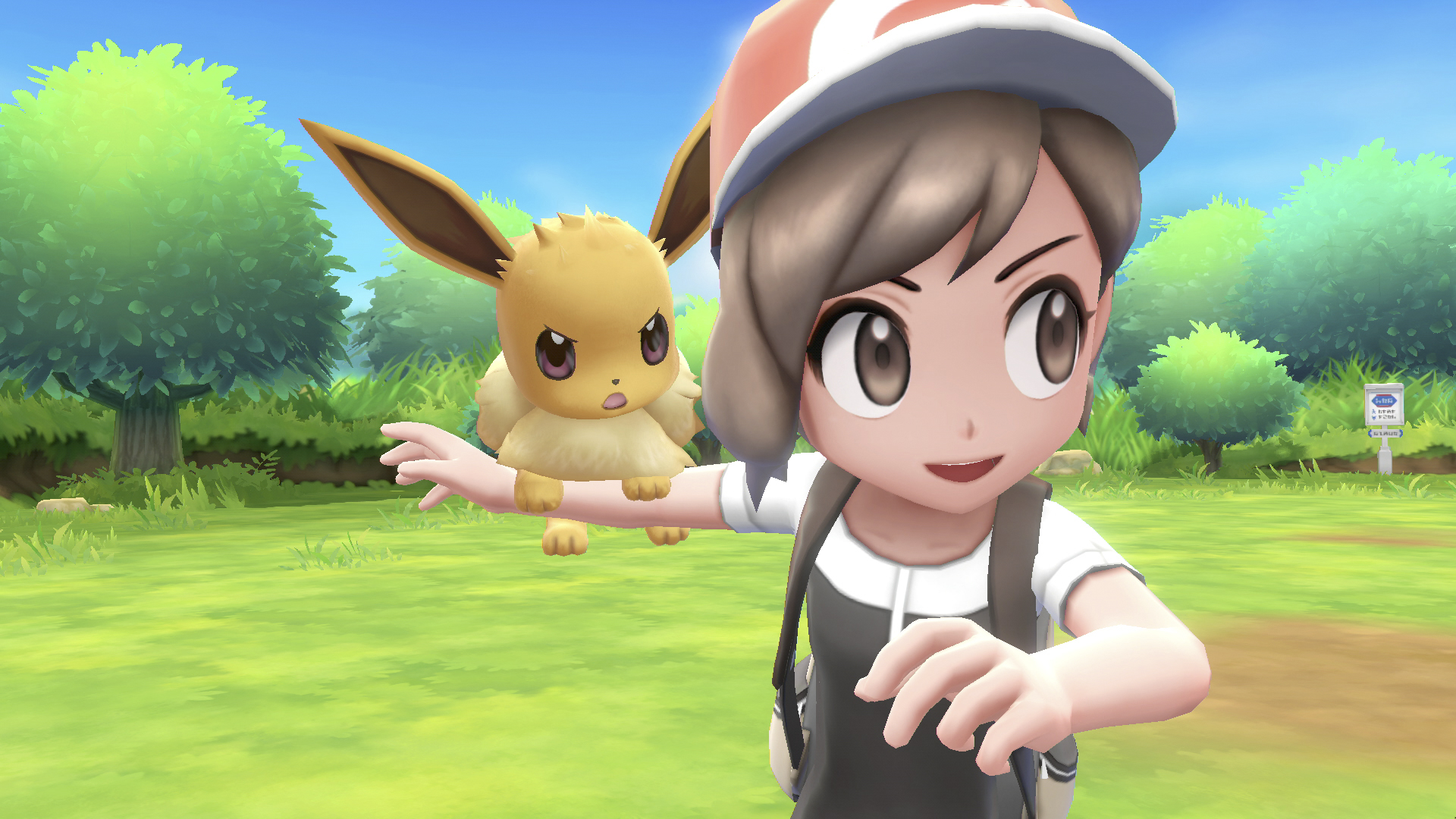 Ein Mädchen mit Evoli. Ein junges Mädchen mit Hut lächelt in die Kamera und hält ein Pokémon.