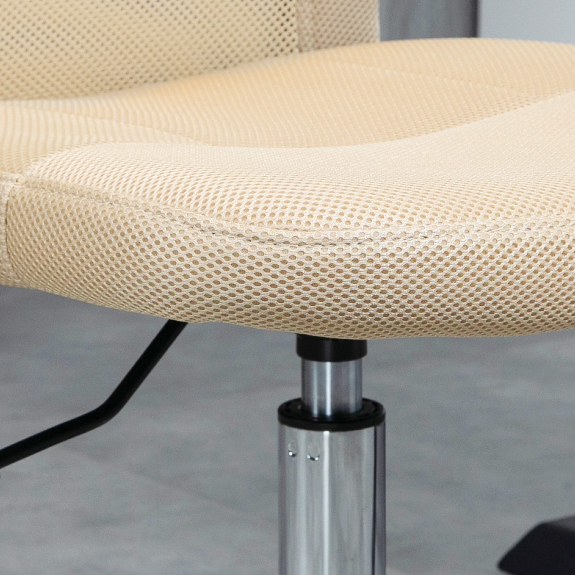 Primer plano de un asiento de silla de malla beige con soporte metálico y base negra.