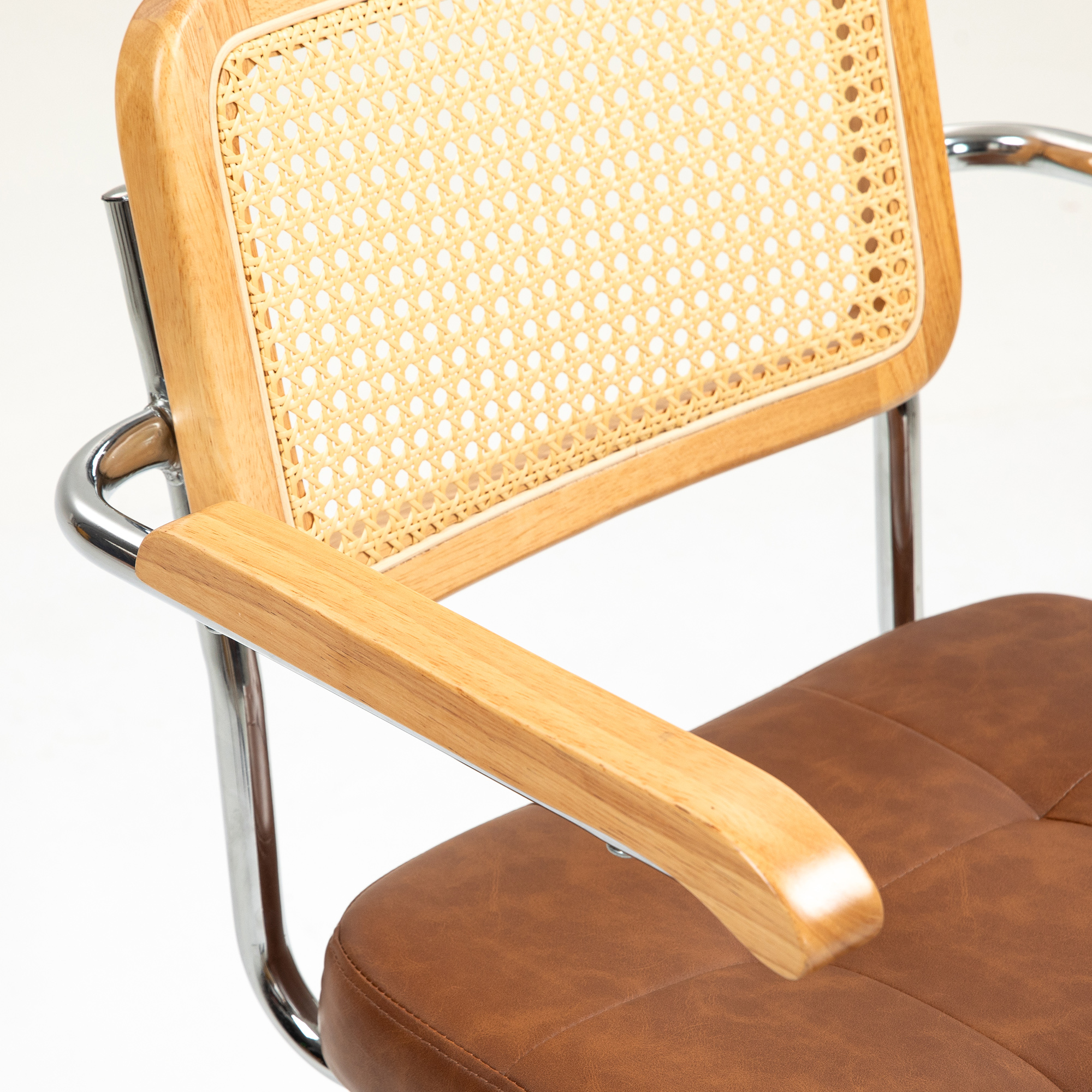 Una silla con marco de madera, respaldo tejido y asiento de cuero sobre blanco.