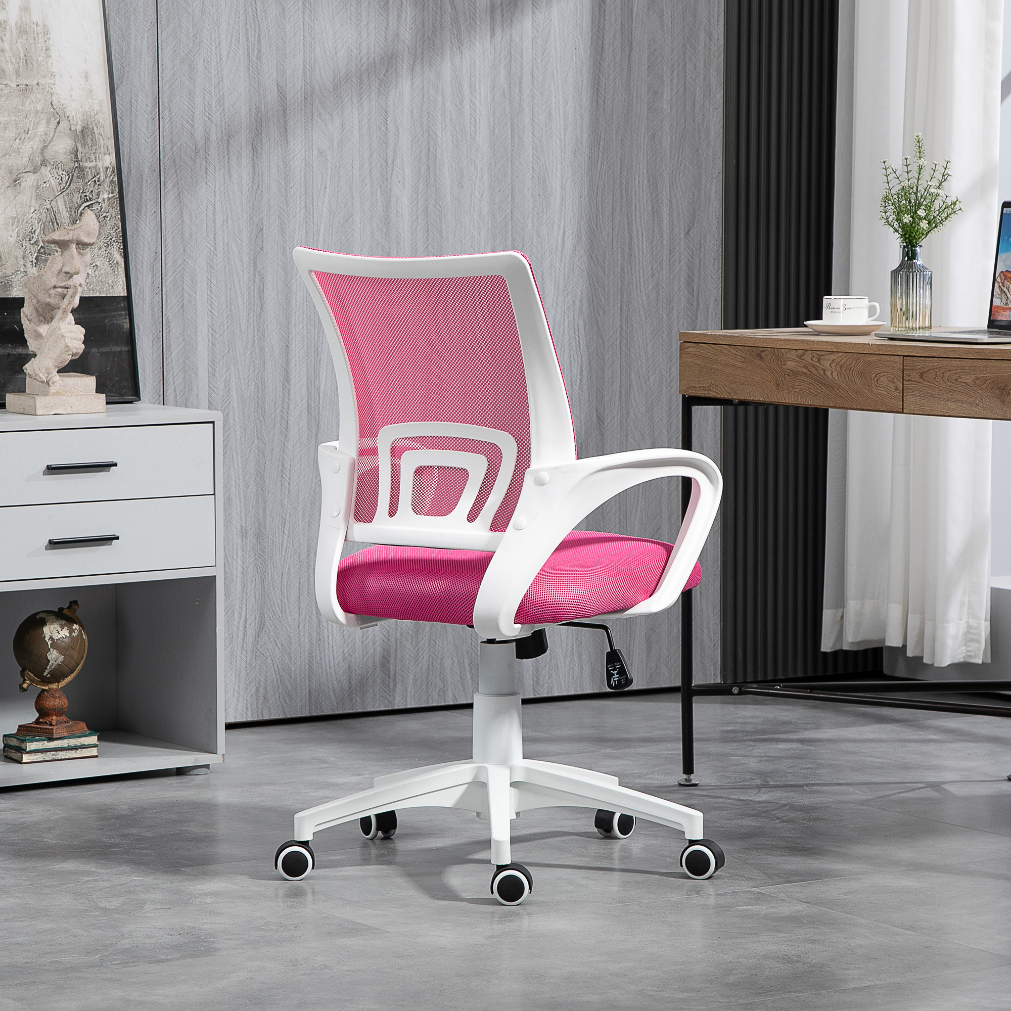 Silla de oficina con respaldo de malla rosa y marco blanco. Está en una habitación con escritorio y ventana.
