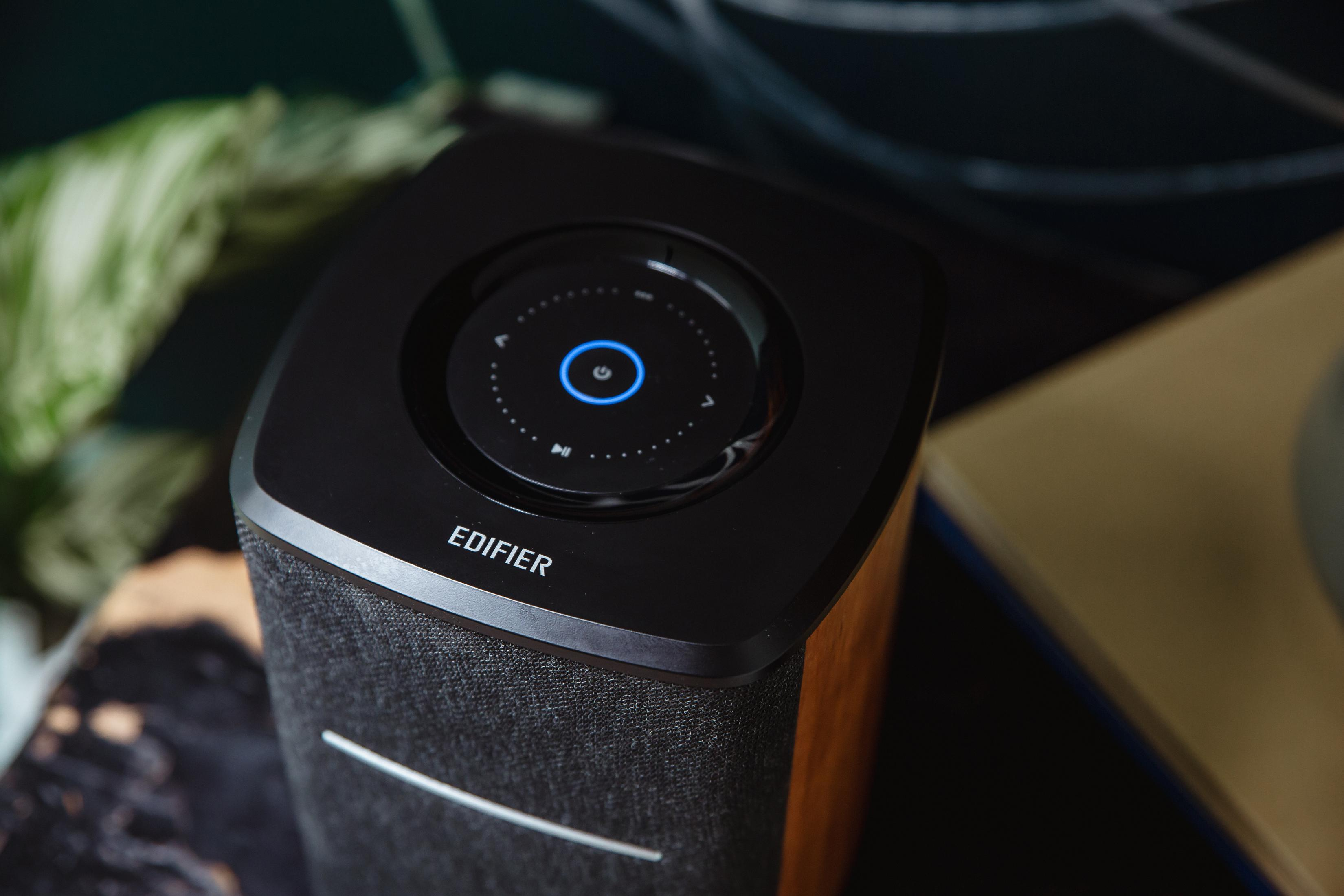 Czarny głośnik z panelem sterowania, drewnianymi bokami i materiałowym przodem.