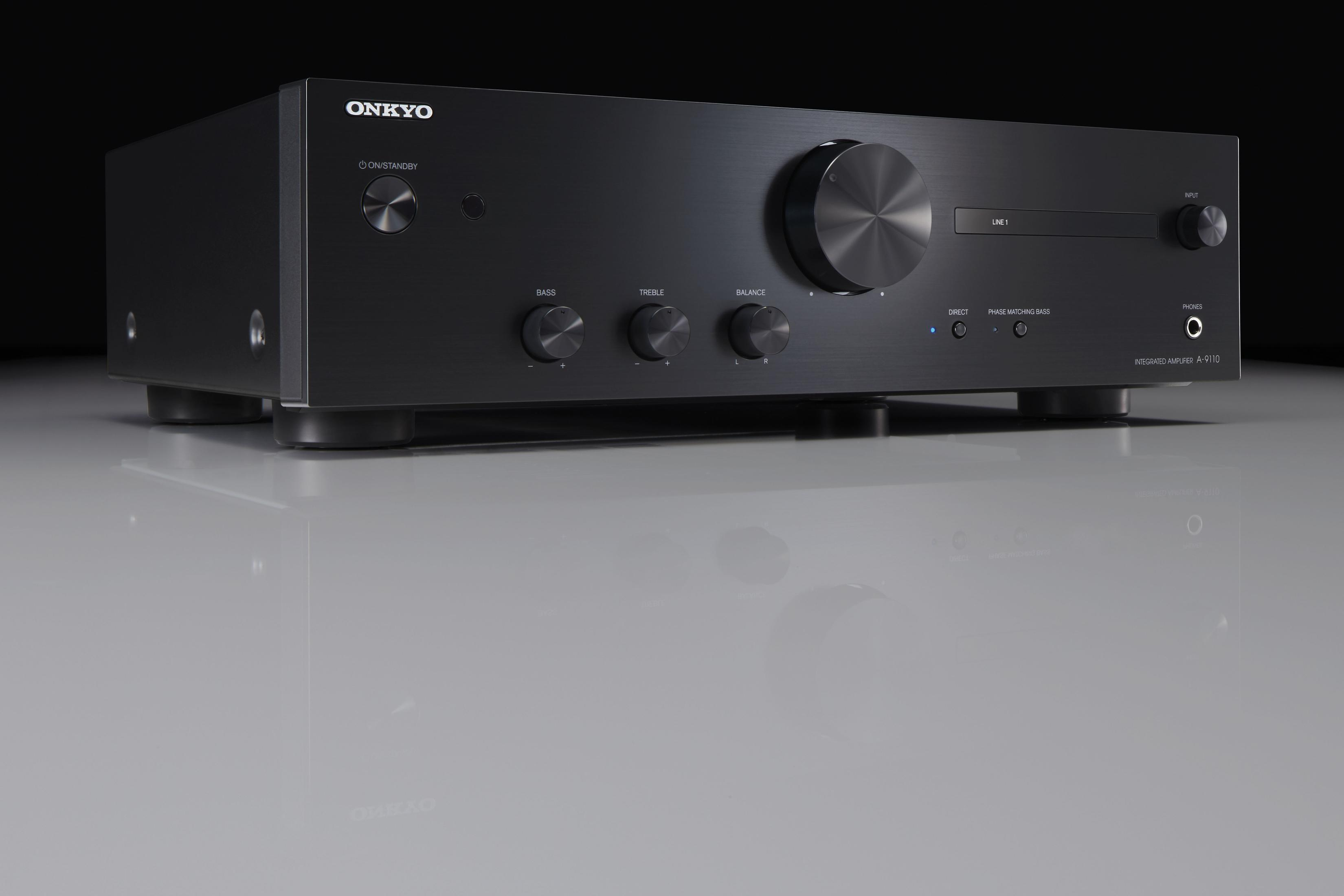 Schwarzer Stereo-Receiver mit Knöpfen und Tasten, auf einer weißen Oberfläche. Eine Reflexion ist sichtbar.