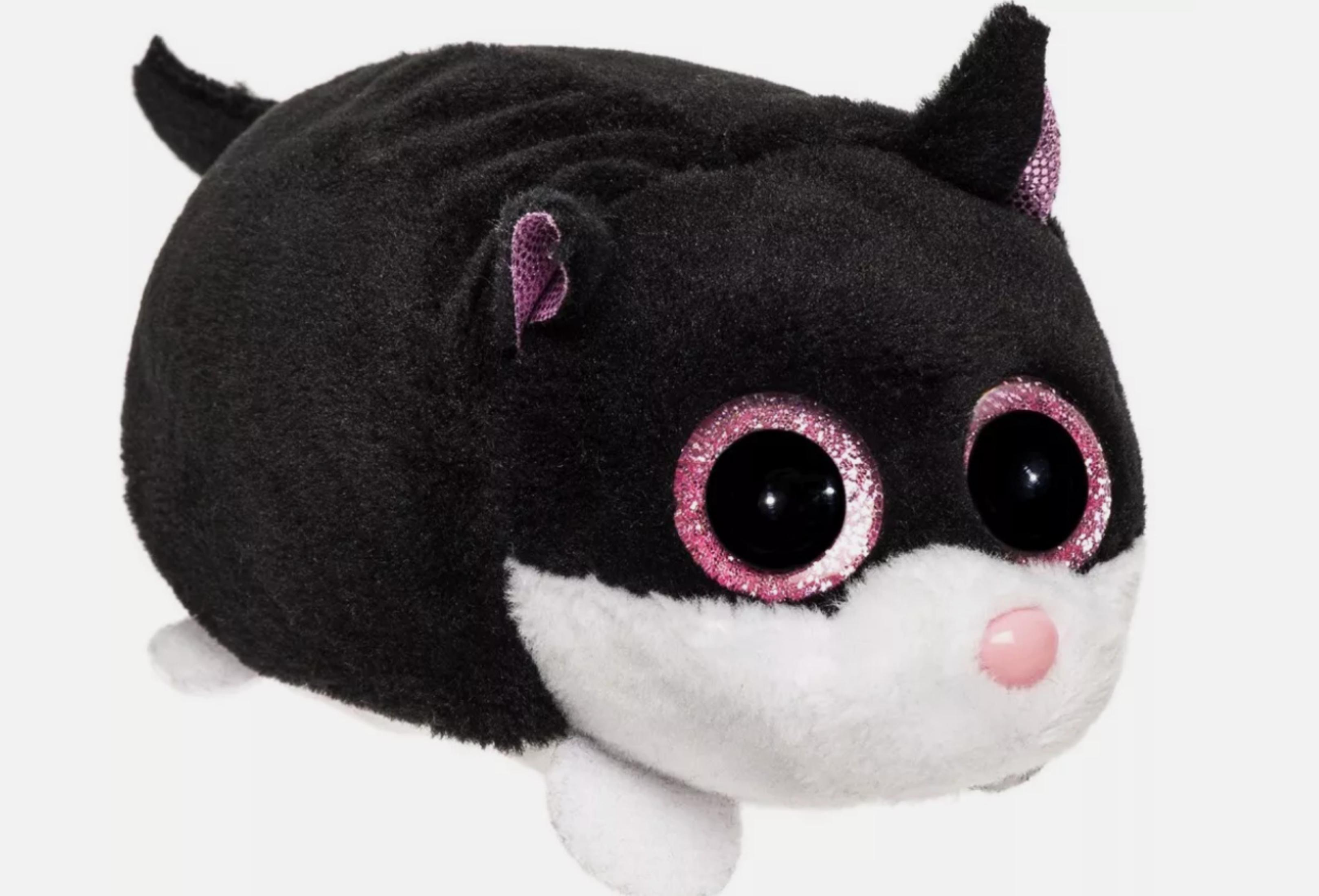 Eine schwarz-weiße Stoffkatze mit großen rosa Augen und einer rosa Nase.