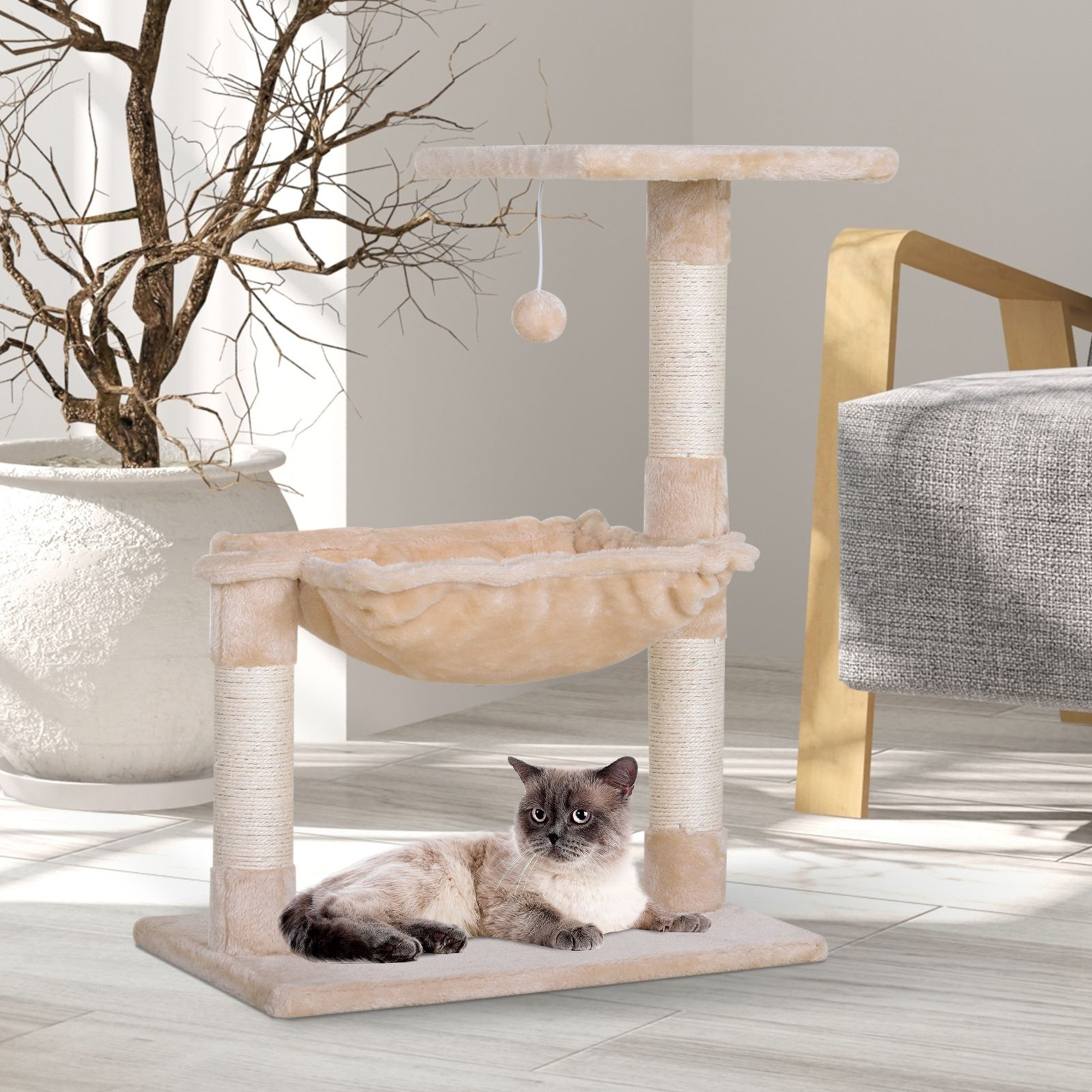 Árbol para gatos con un gato acostado en una cama. El árbol tiene colores beige y marrón.