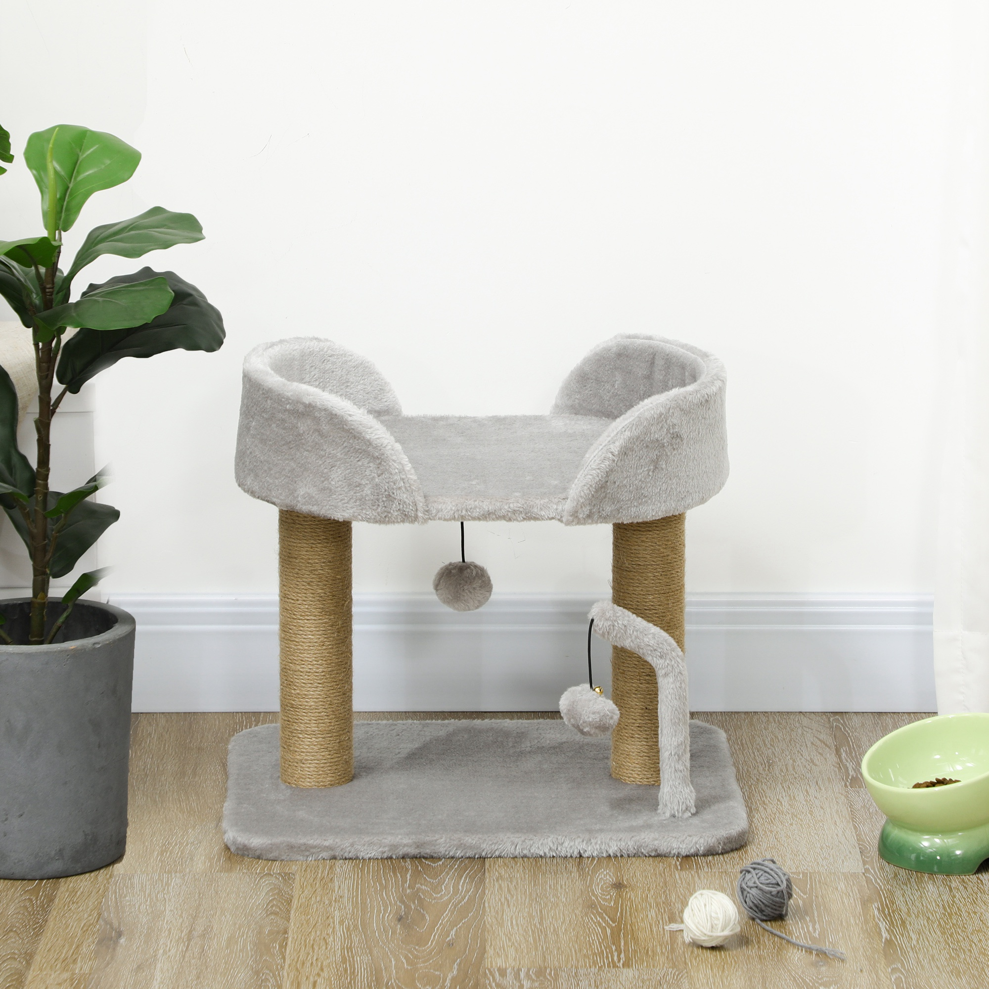 Árbol para gatos con postes para rascar, una plataforma y un juguete colgante. Es gris y está sobre un suelo de madera.