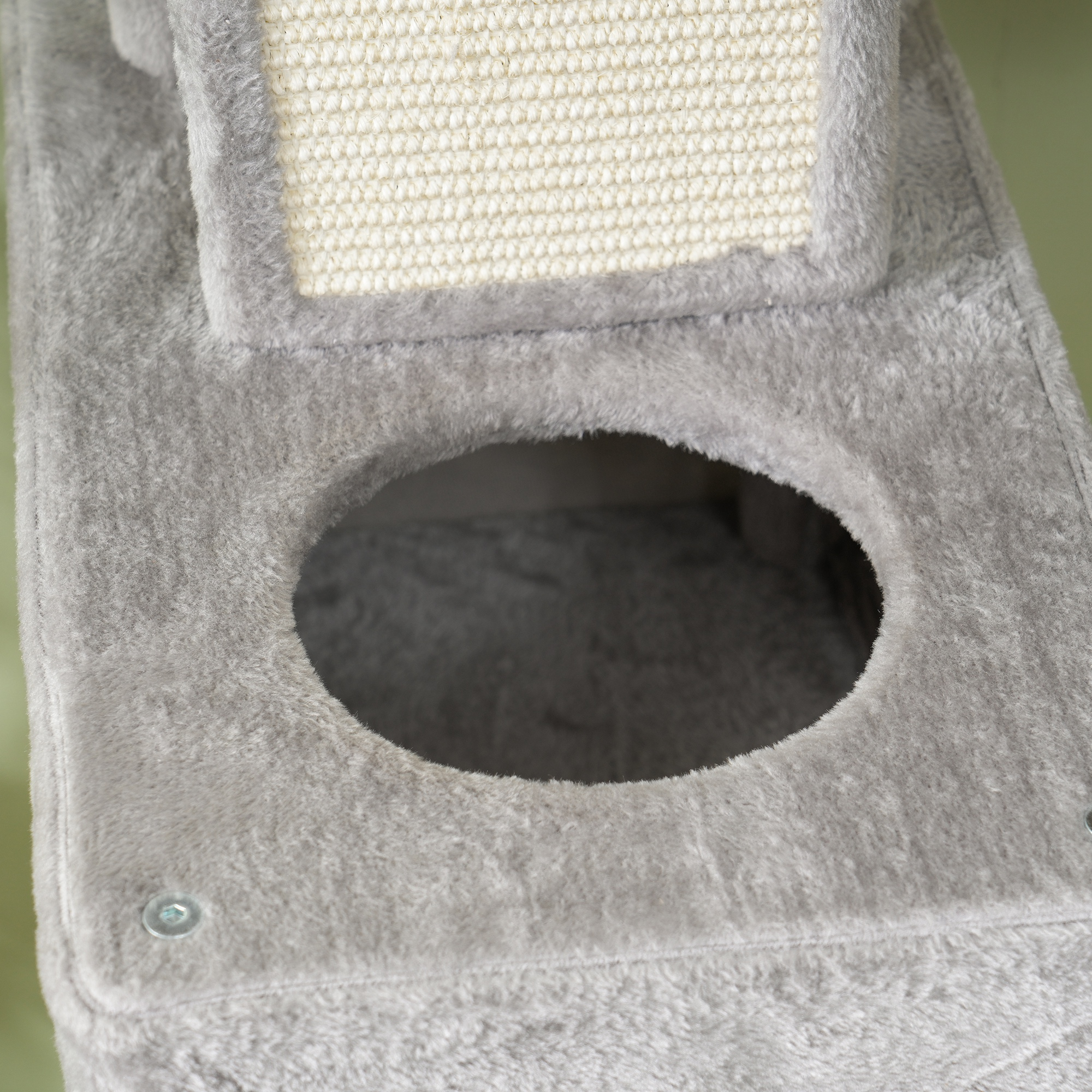 Primer plano de una plataforma de árbol para gatos con un agujero redondo.