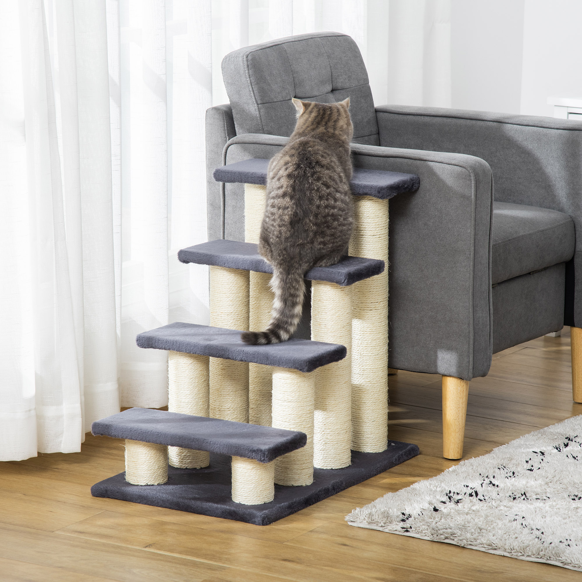Gato subiendo escaleras. El gato es gris, sentado en un árbol para gatos con escaleras grises.