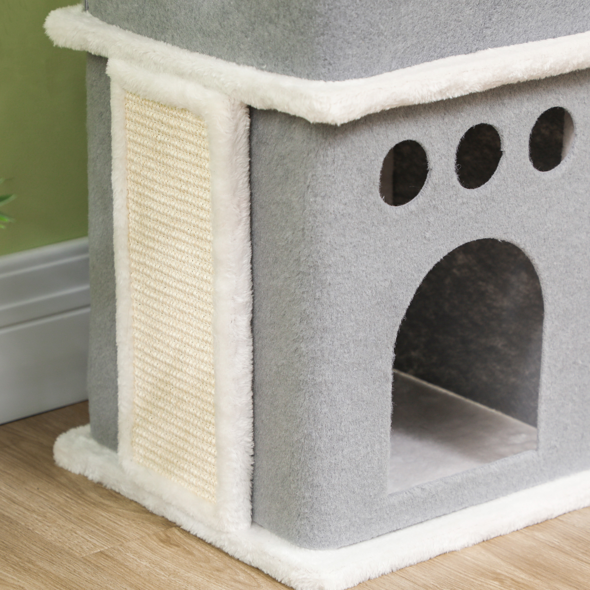 Primer plano de un árbol para gatos gris con poste rascador y una puerta.