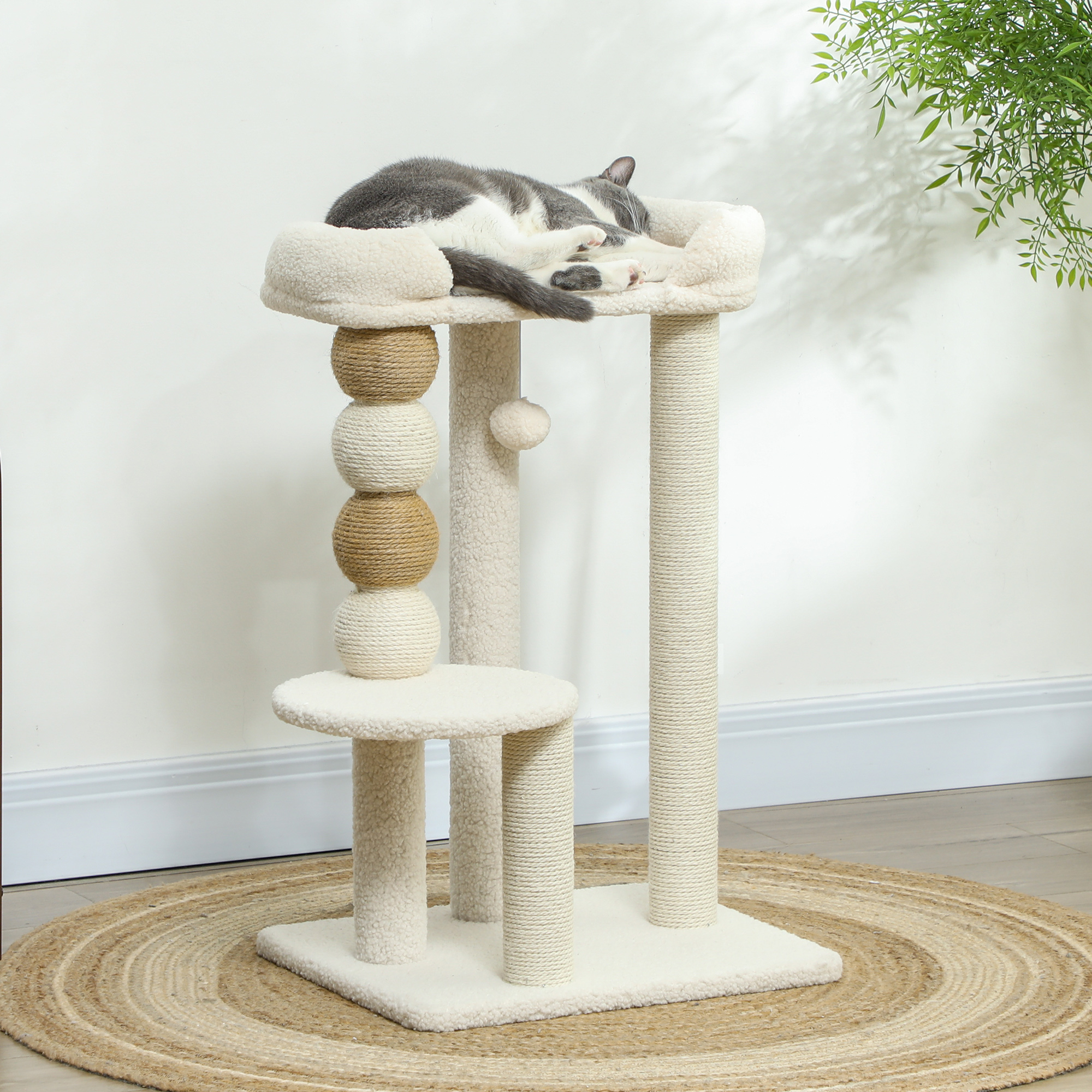 Gato durmiendo en un árbol para gatos. Colores beige y blanco. Alfombra redonda de yute. Tonos beige y marrón.