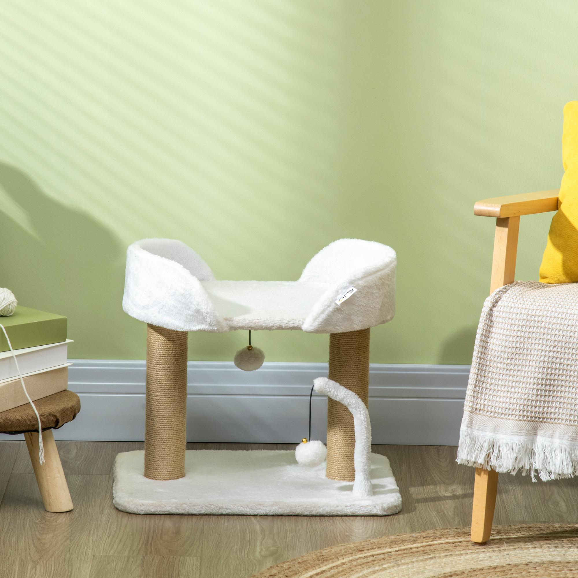 Árbol para gatos blanco con cama y dos bolas colgantes. Una silla y una alfombra en el fondo.