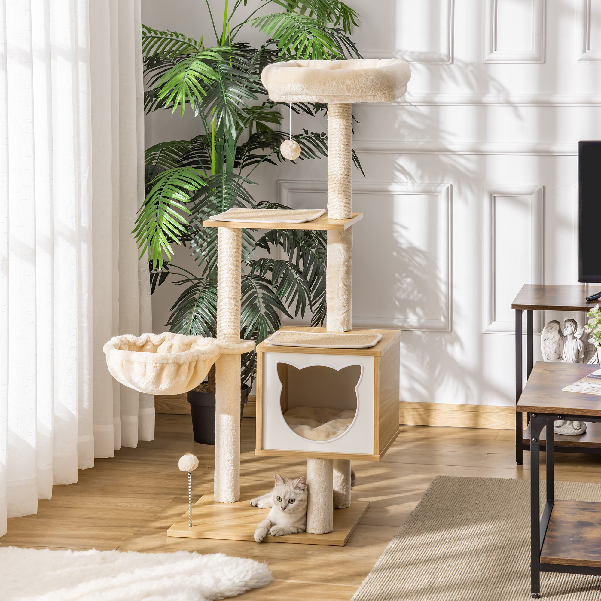 Un albero per gatti in una stanza. Un gatto è su una piattaforma e un altro è sdraiato vicino a una cuccia.