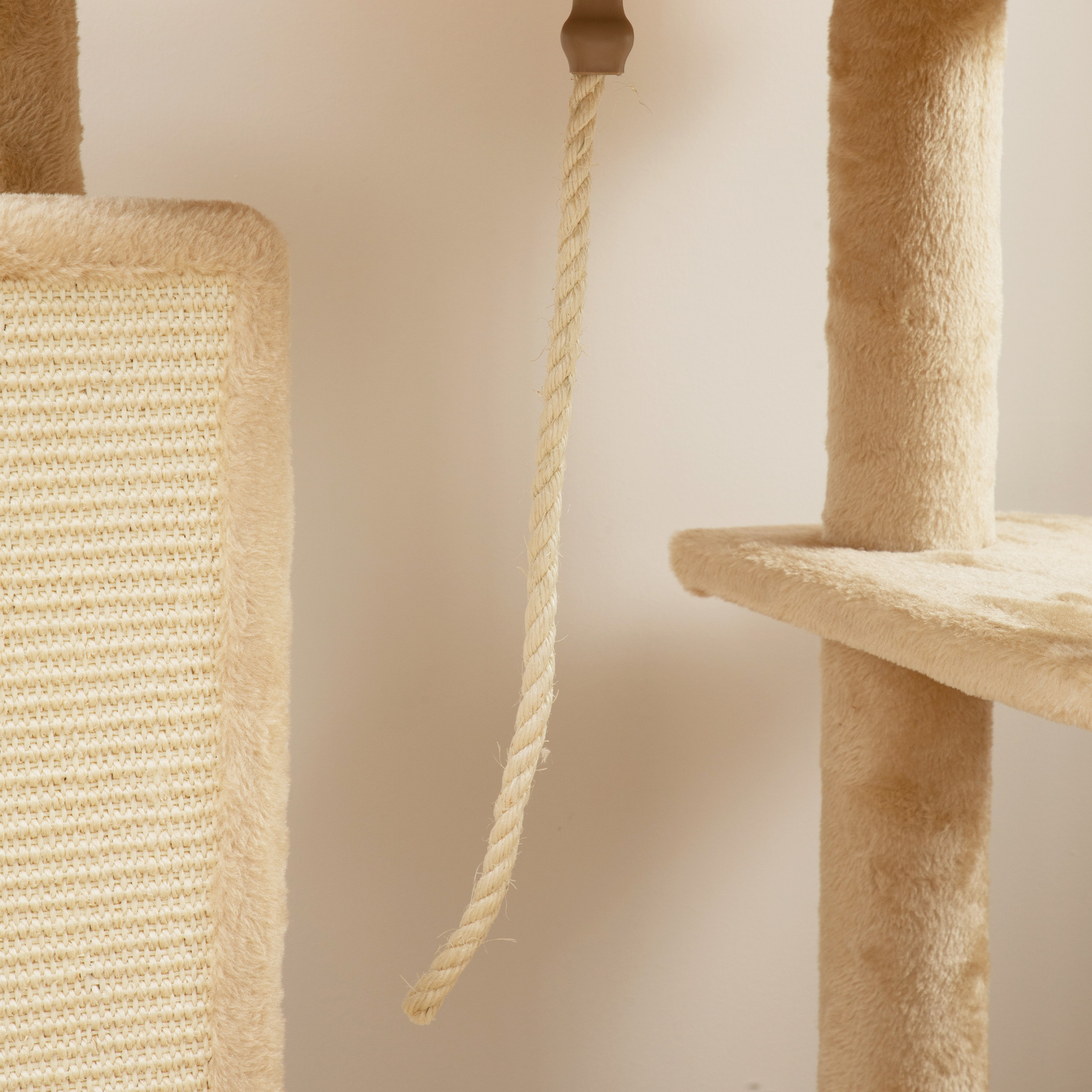 Primer plano del poste rascador y la cuerda de un árbol para gatos beige. Se ve la textura y la construcción.