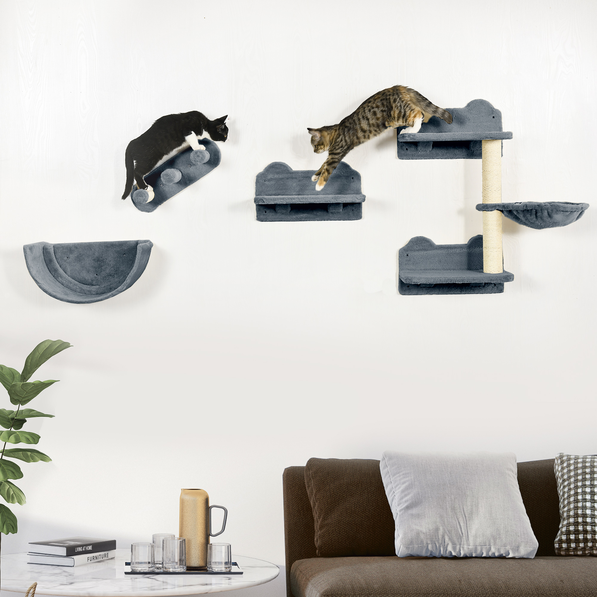 Gatos en un árbol para gatos montado en la pared con múltiples niveles y un sofá marrón en primer plano.
